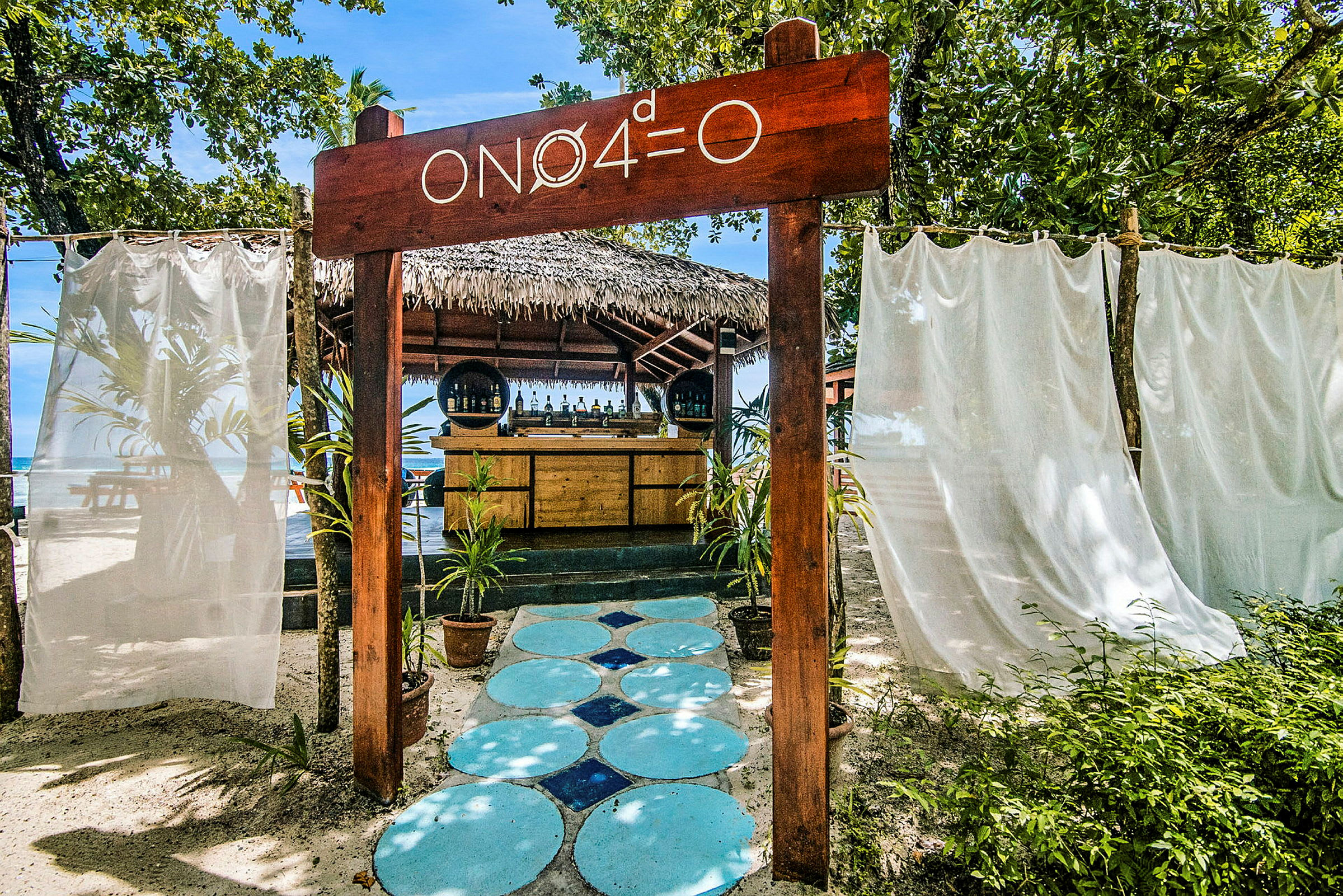 Strandbar med skilt og omgivelser af vegetation. (AI-genereret tekst)