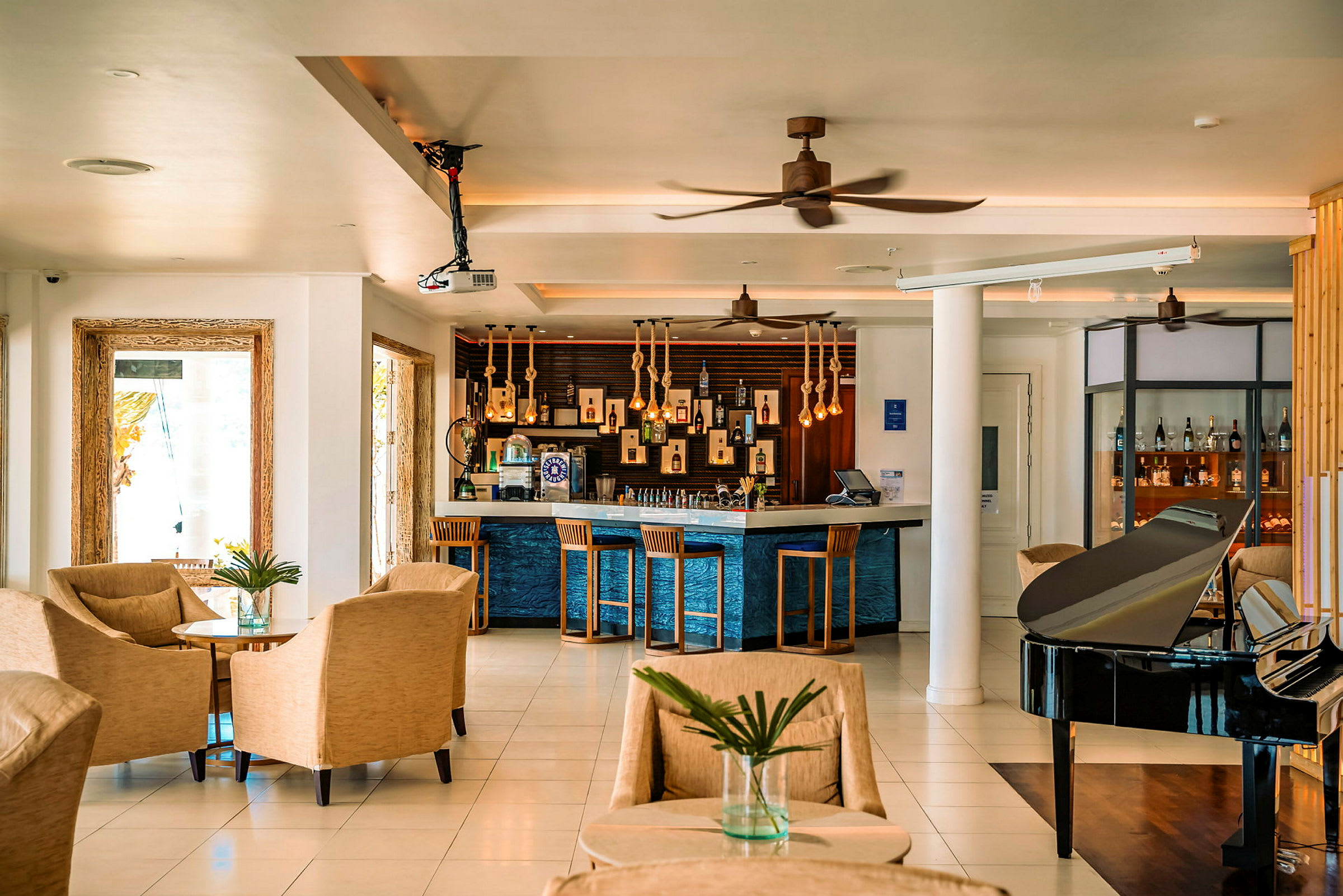 Hotel lobby med siddepladser, bar og sort klaver. (AI-genereret tekst)