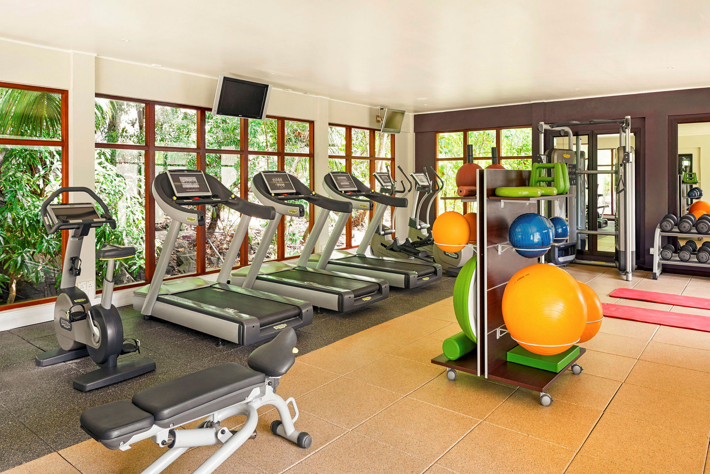 Et fitnesscenter med løbebånd, motionscykel og træningsudstyr. (AI-genereret tekst)