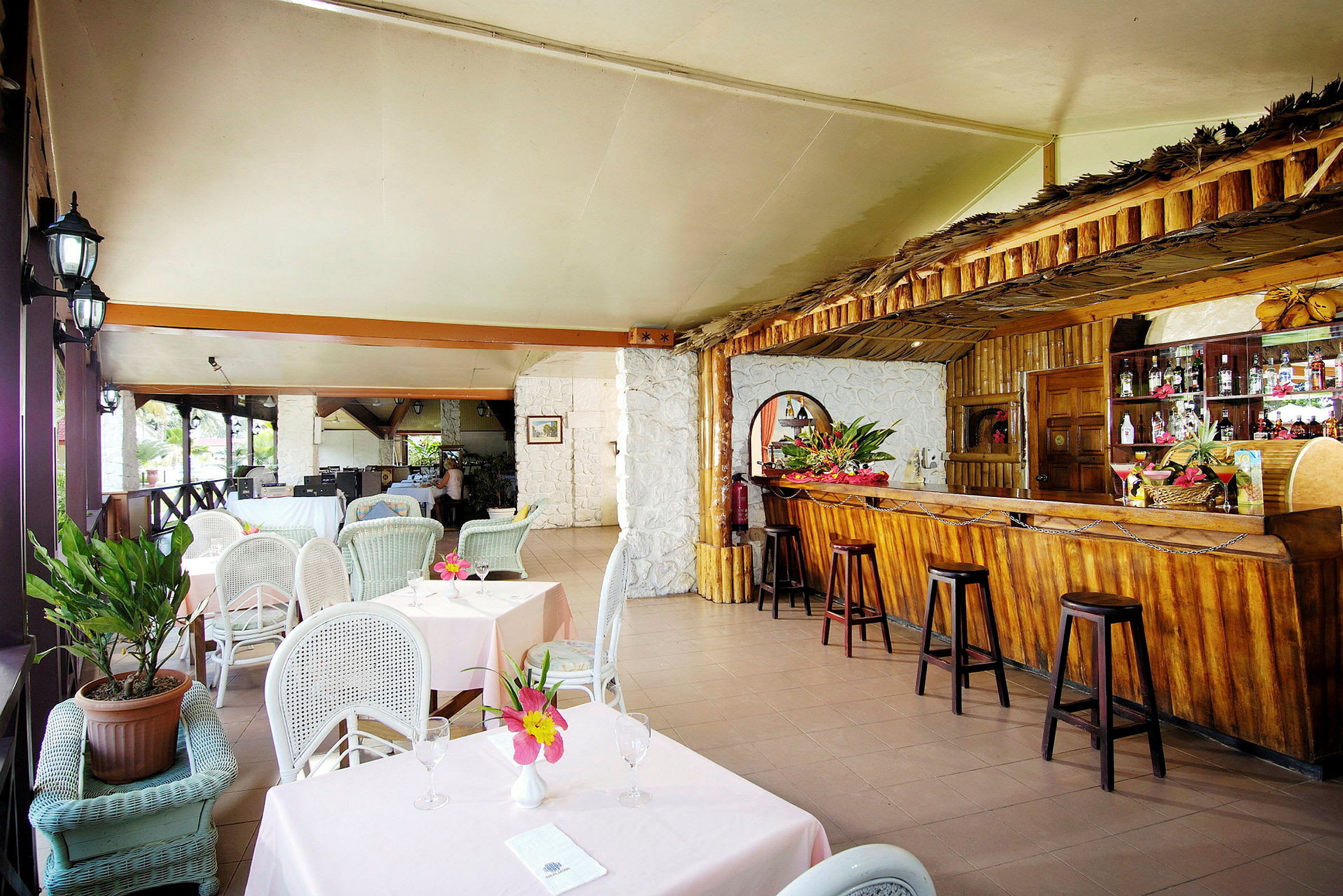 En restaurant med opstillede siddepladser og en træbar med dekorationer. (AI-genereret tekst)