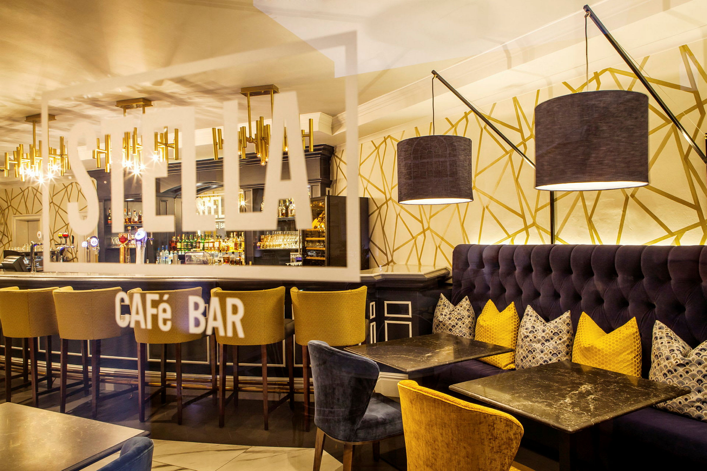 Interiør af en stilfuld cafébar med sofaer, borde og en bardisk. (AI-genereret tekst)