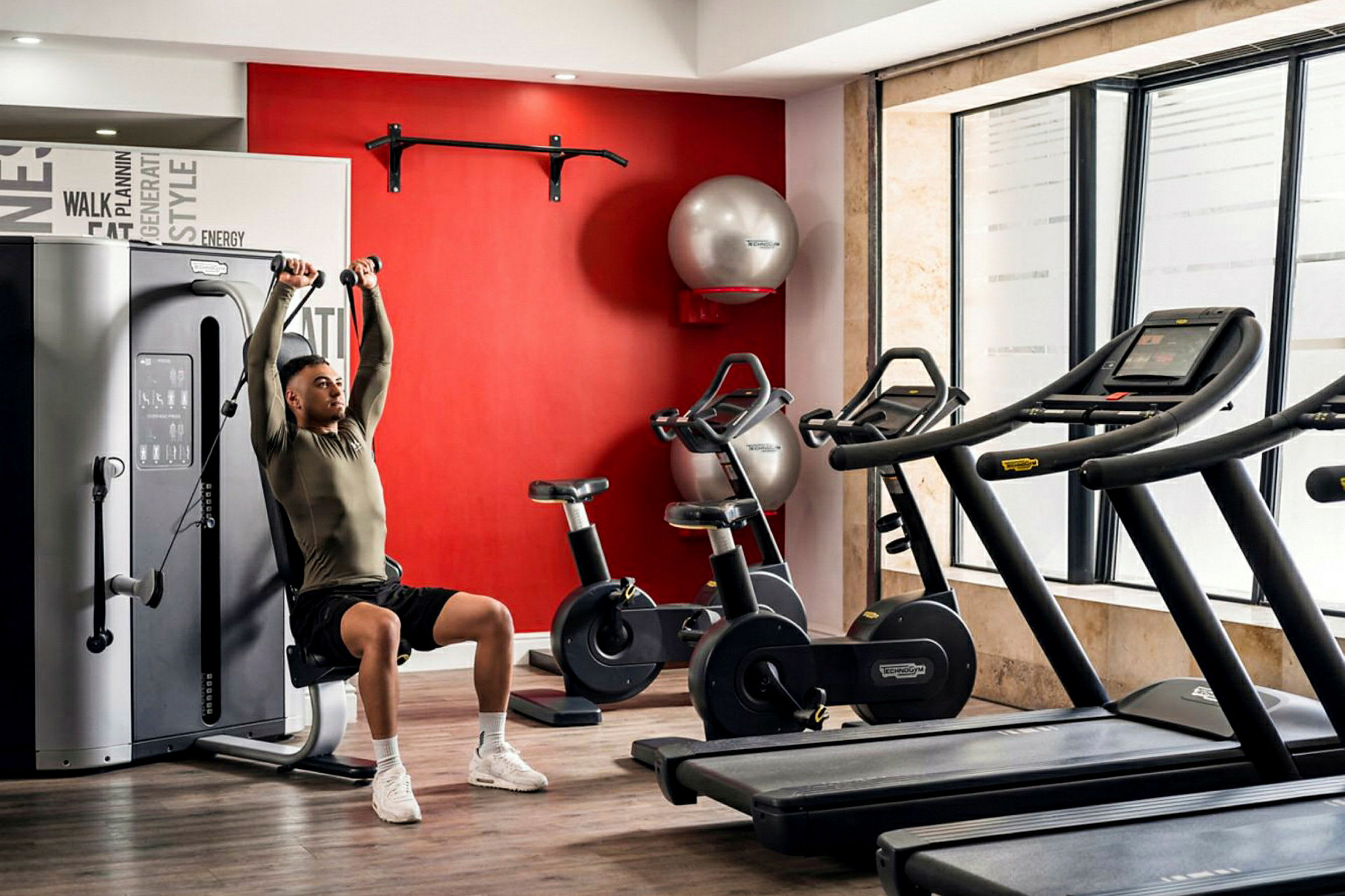 Et fitnesscenter med træningsmaskiner, motionscykler og løbebånd. (AI-genereret tekst)