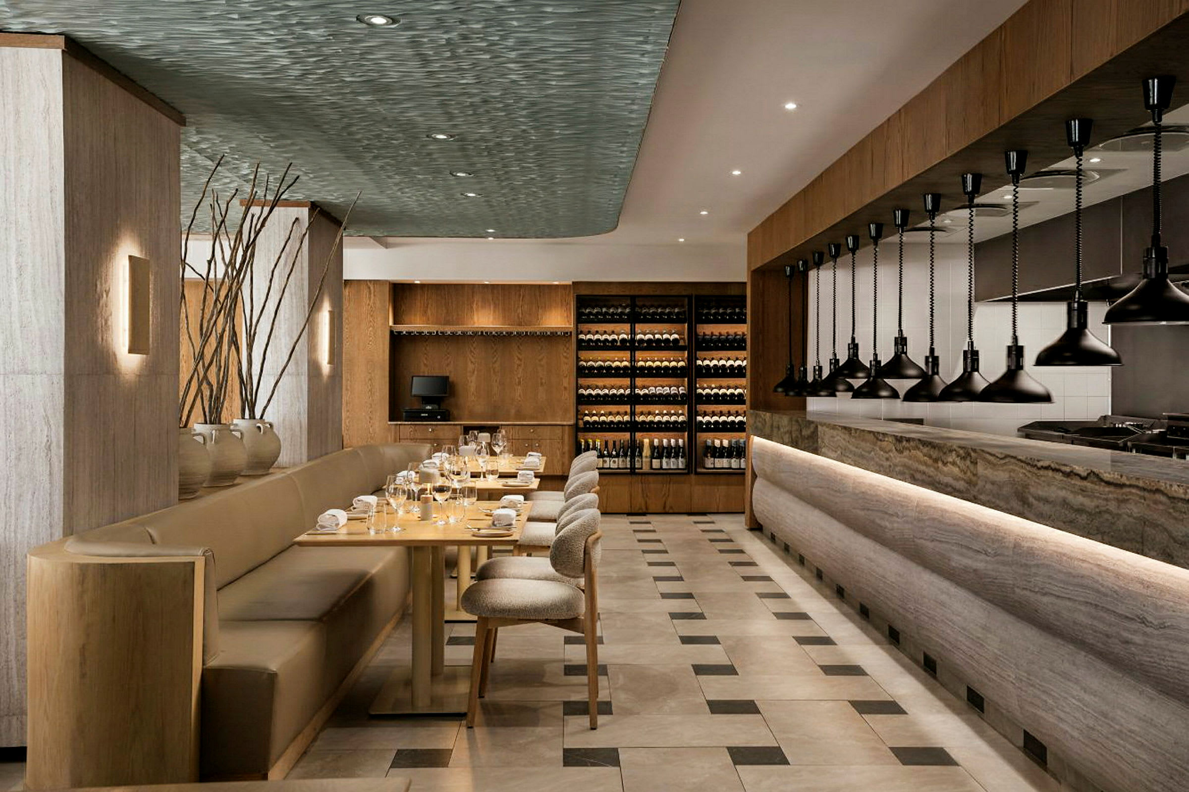 Interiør af en elegant restaurant med siddepladser, borde og et åbent køkkenområde. (AI-genereret tekst)