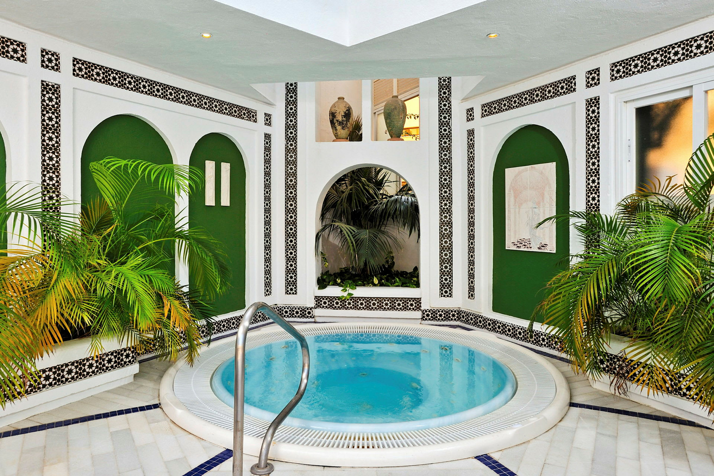 Interiør med jacuzzi, grønne planter og hvid vægdekoration. (AI-genereret tekst)