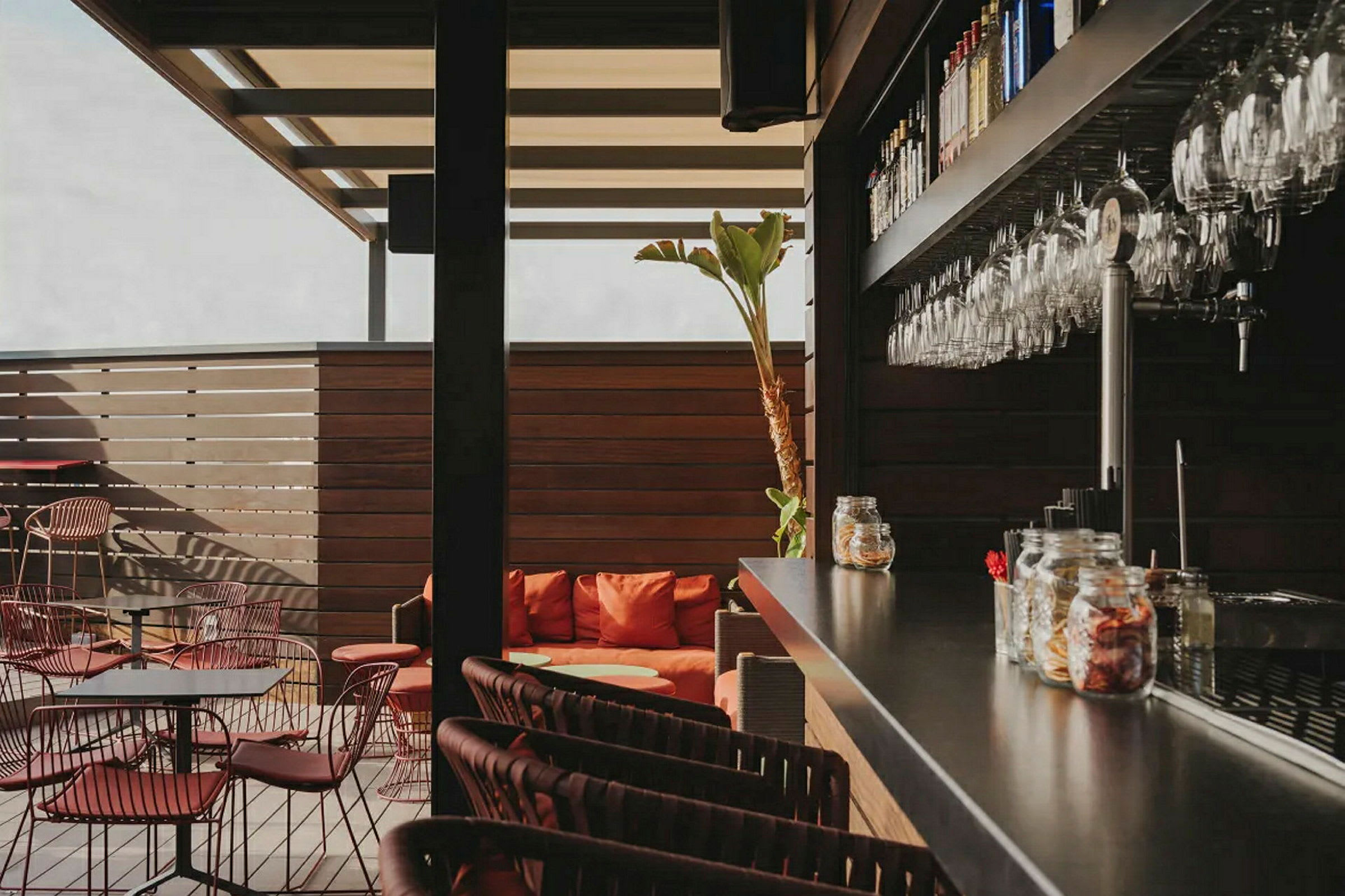 En moderne bar med siddepladser og glas hængende på væggen. (AI-genereret tekst)