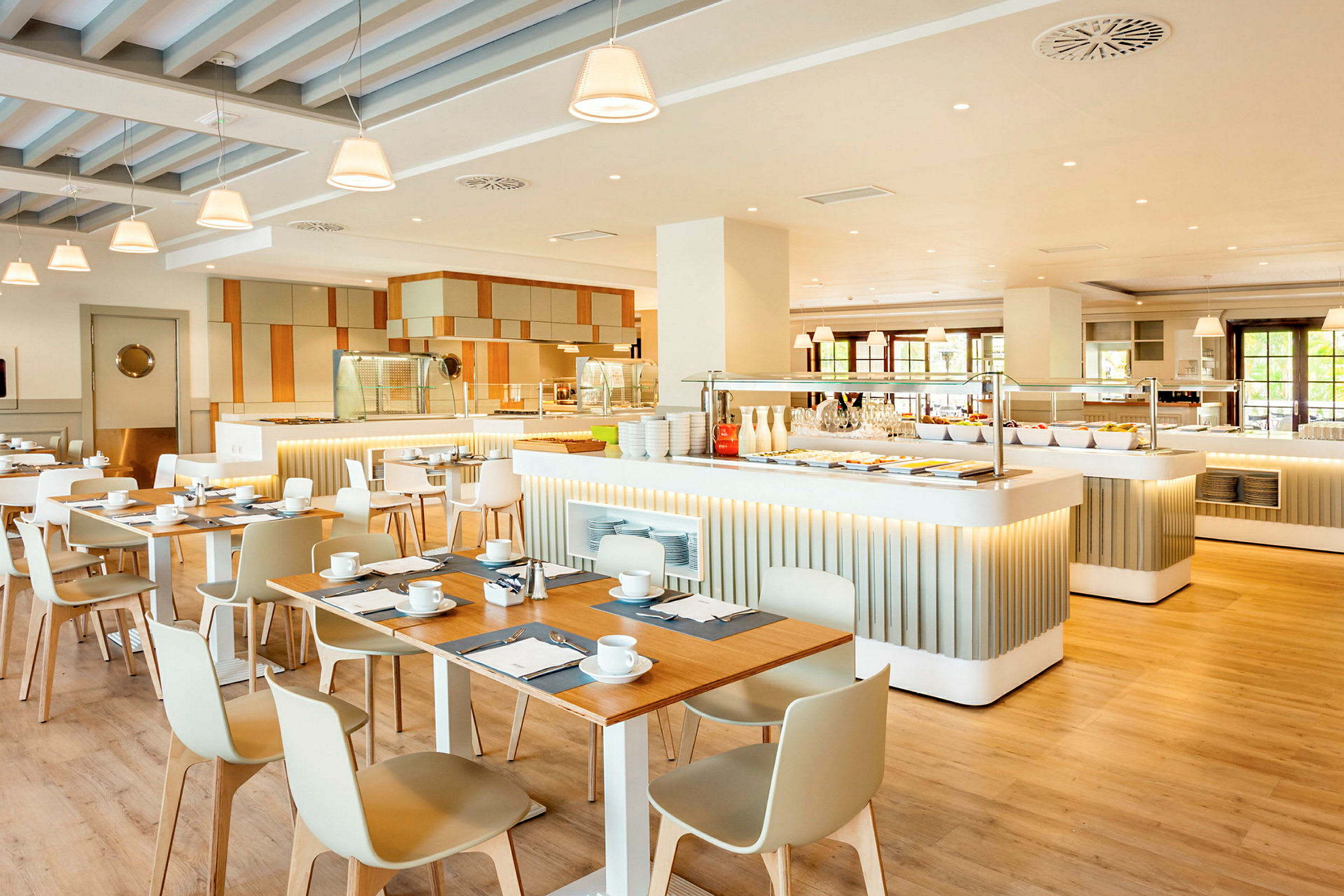 Billede af en lys og moderne restaurant med borde, stole og en buffetdisk. (AI-genereret tekst)