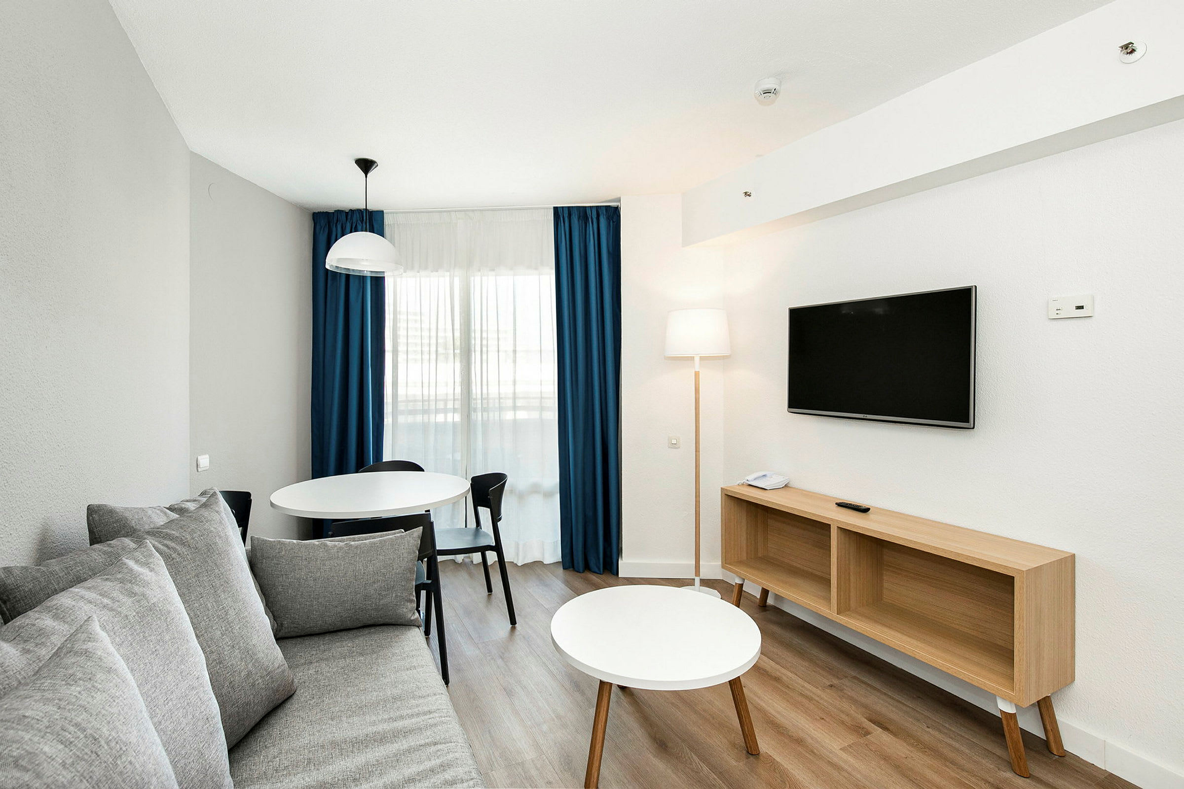 En moderne indrettet stue med sofa, spisebord og tv. (AI-genereret tekst)