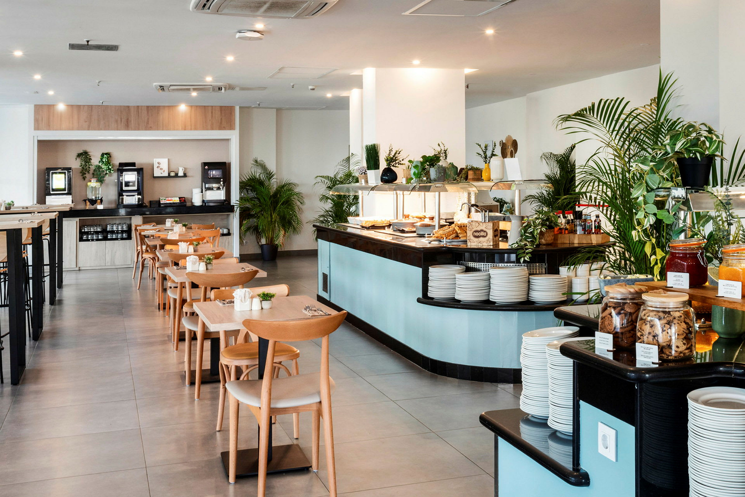 Et rummeligt restaurantområde med borde og stole samt en buffet fyldt med forskellige retter. (AI-genereret tekst)