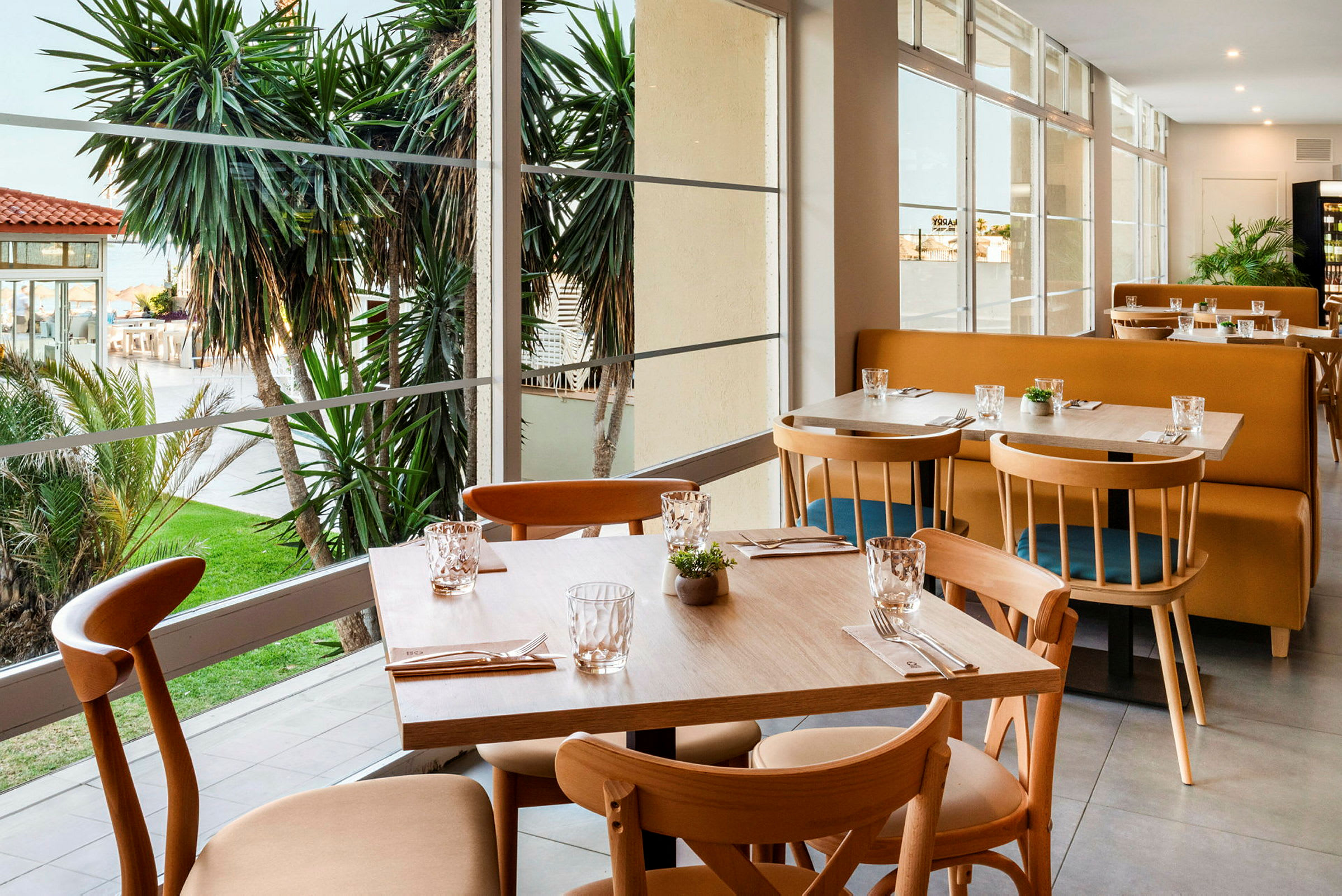 Restaurant med udsigt over haven og palmer. (AI-genereret tekst)