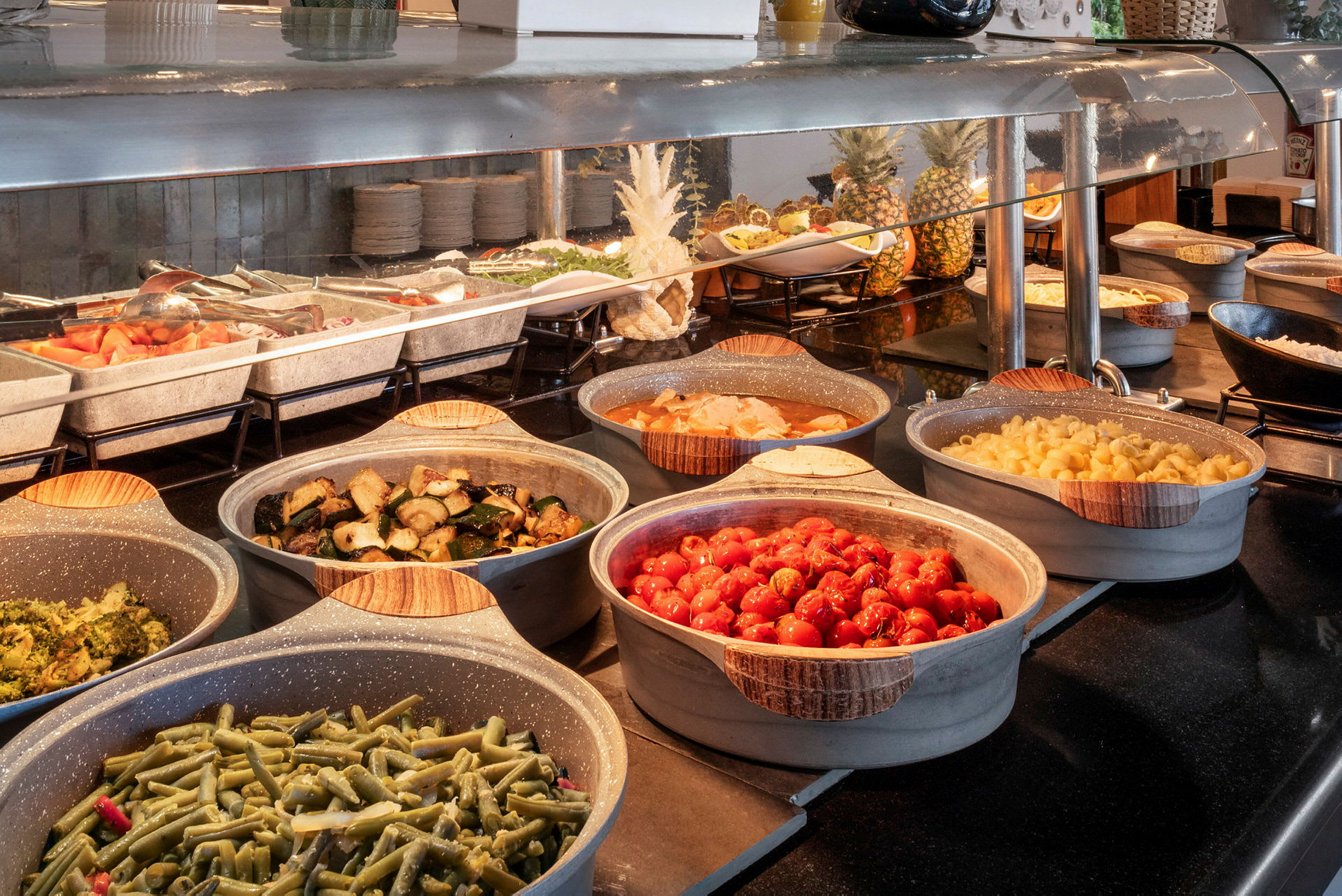 Buffet med forskellige retter, herunder grøntsager og pasta. (AI-genereret tekst)