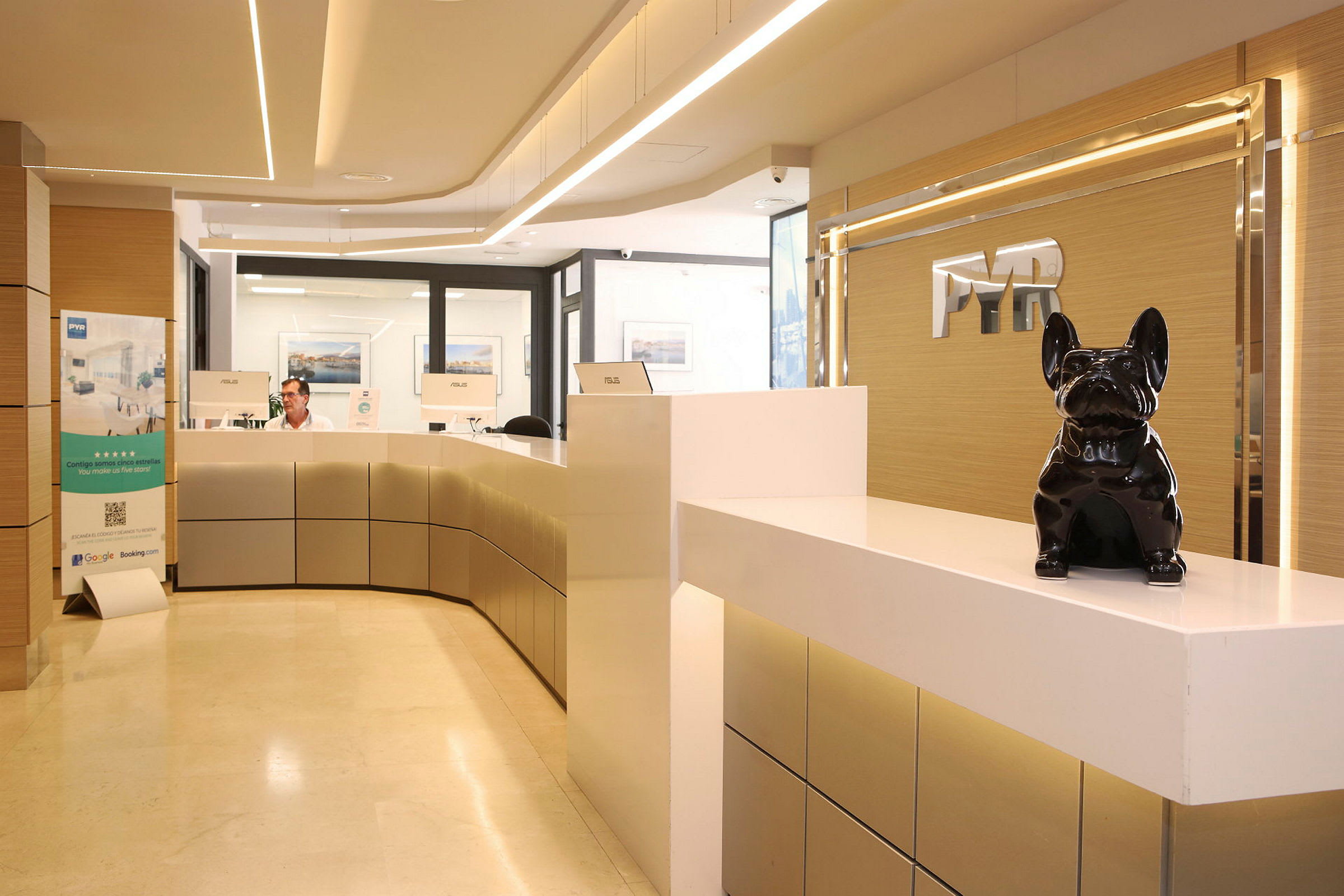 Reception med moderne indretning og en sort hundestatue på disken. (AI-genereret tekst)