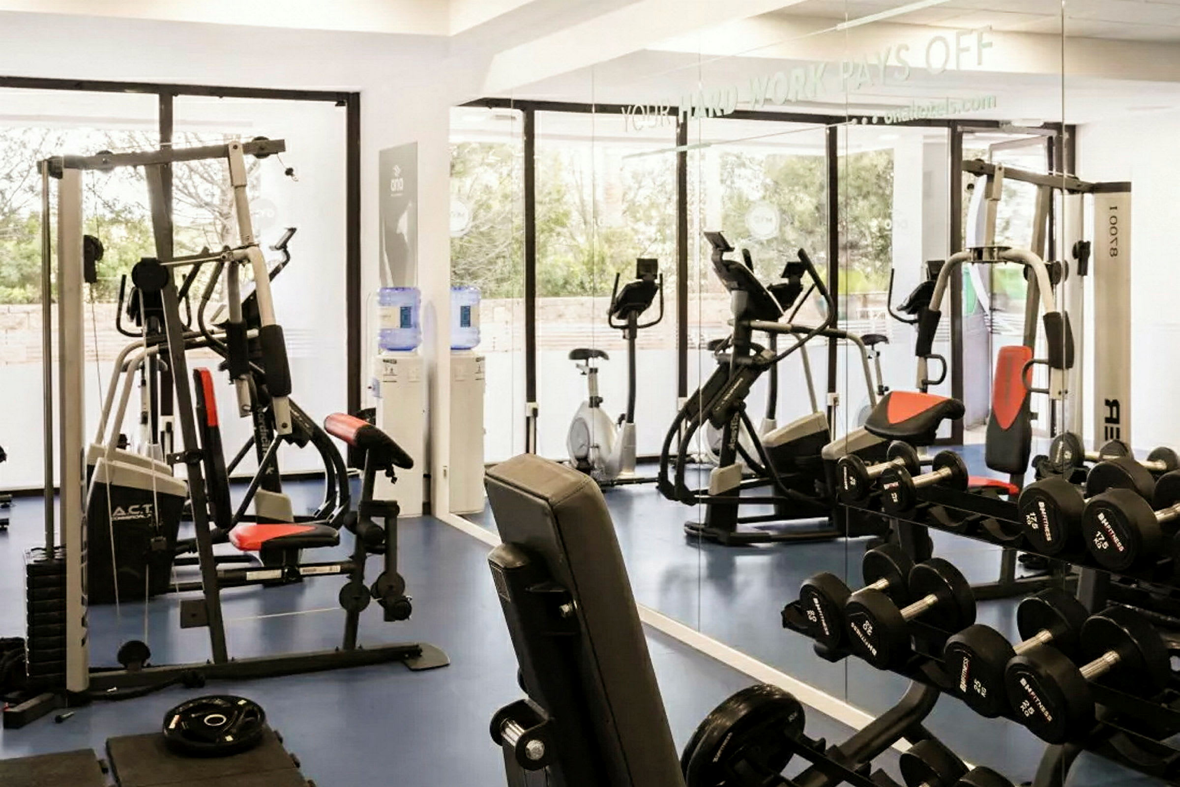 Et fitnesscenter med maskiner og vægte til træning. (AI-genereret tekst)