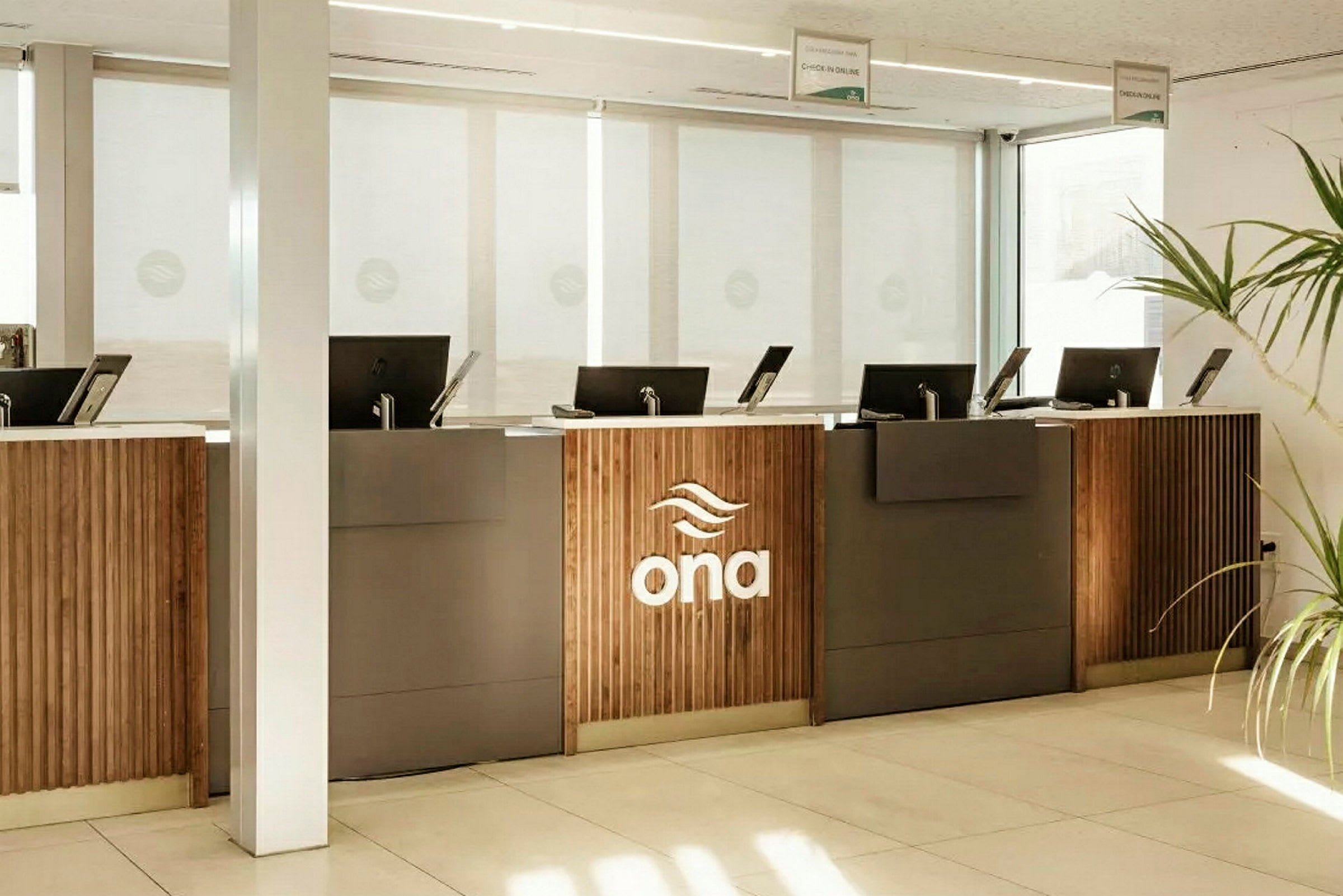 Reception med flere skranker og logoen "ona" synlig på en af dem. (AI-genereret tekst)