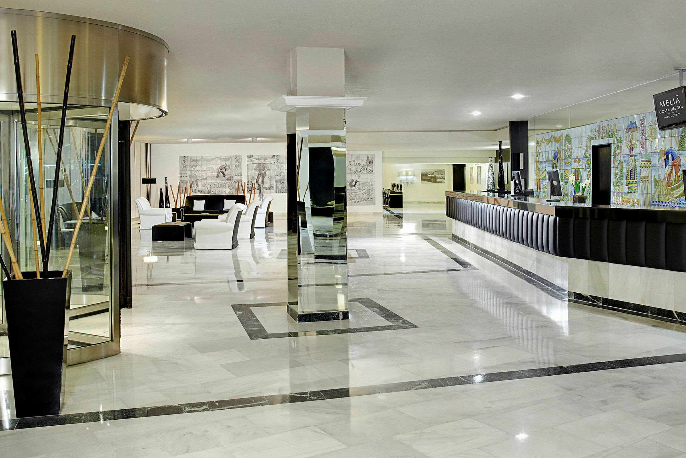 Hotellets lobby med reception og siddeområder. (AI-genereret tekst)