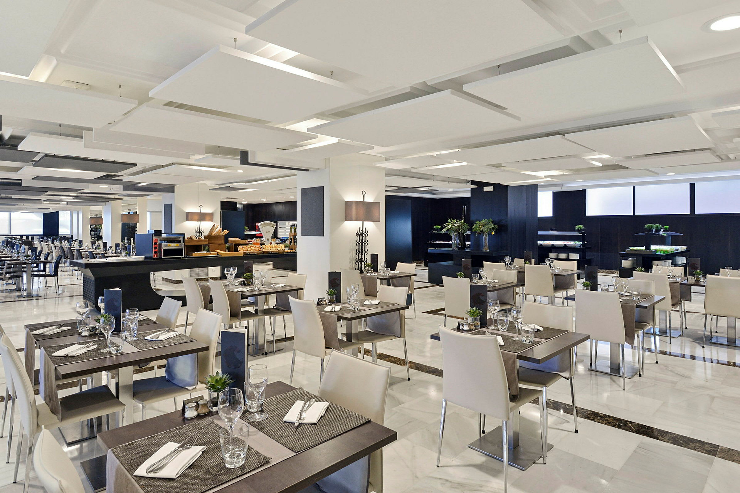 En moderne restaurant med hvidt interiør og dækkede borde. (AI-genereret tekst)