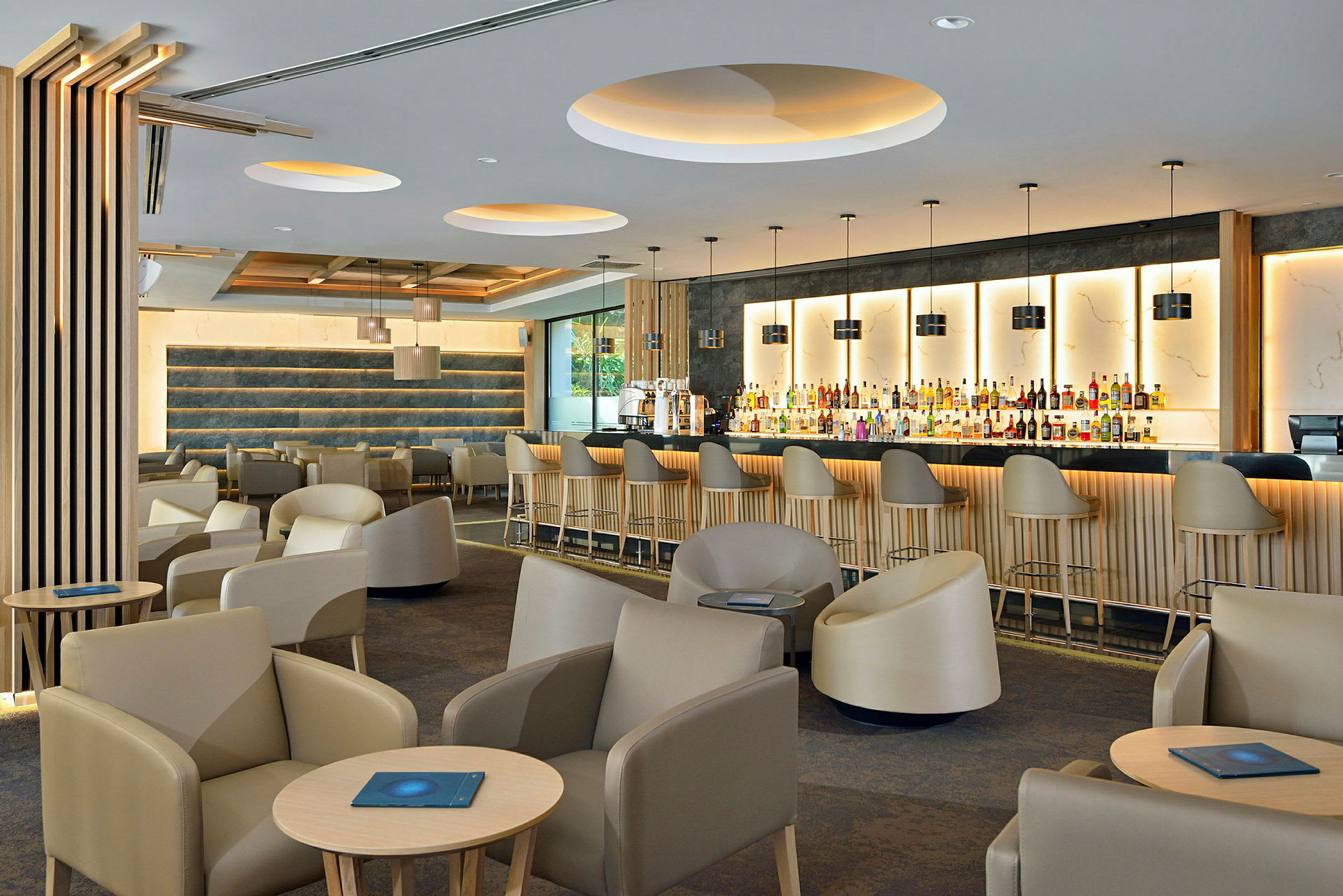 Moderne bar og lounge med komfortable stole og belysning. (AI-genereret tekst)