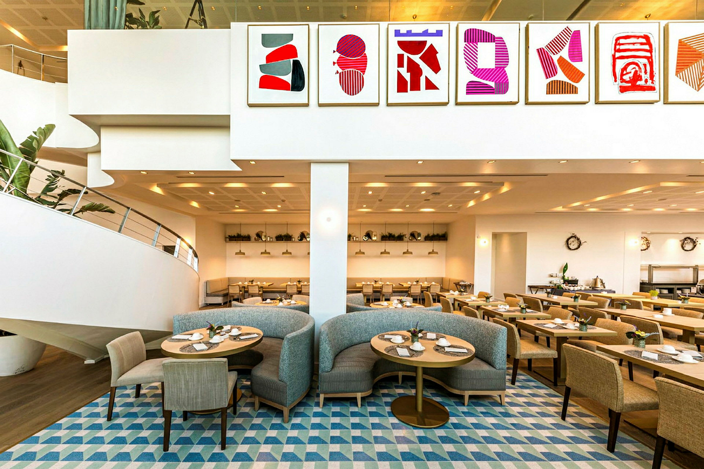 En restaurant med moderne indretning, malerier på væggen og siddepladser med stole og sofaer. (AI-genereret tekst)