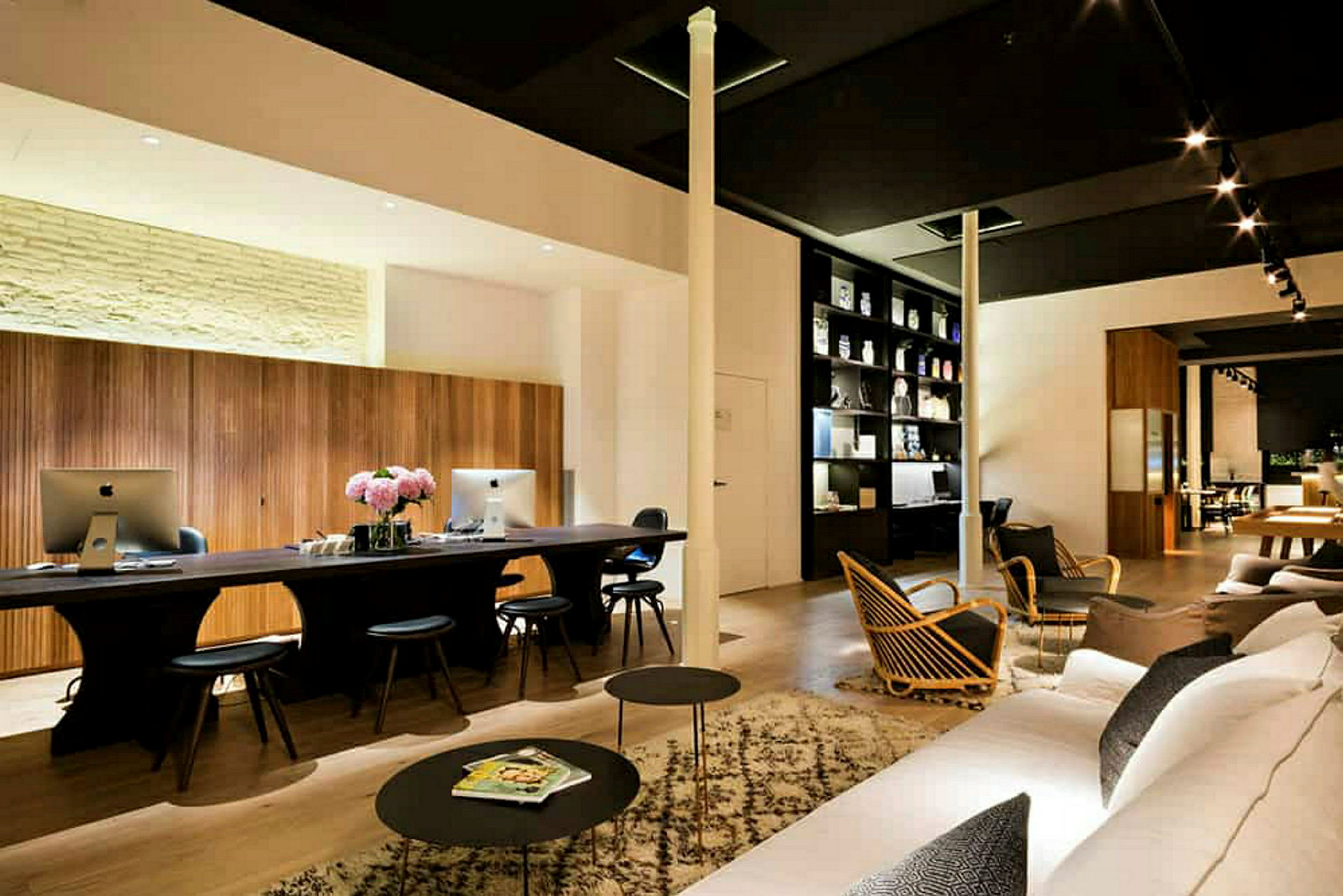 Moderne indrettet lounge med skriveborde, computere og sofaer. (AI-genereret tekst)