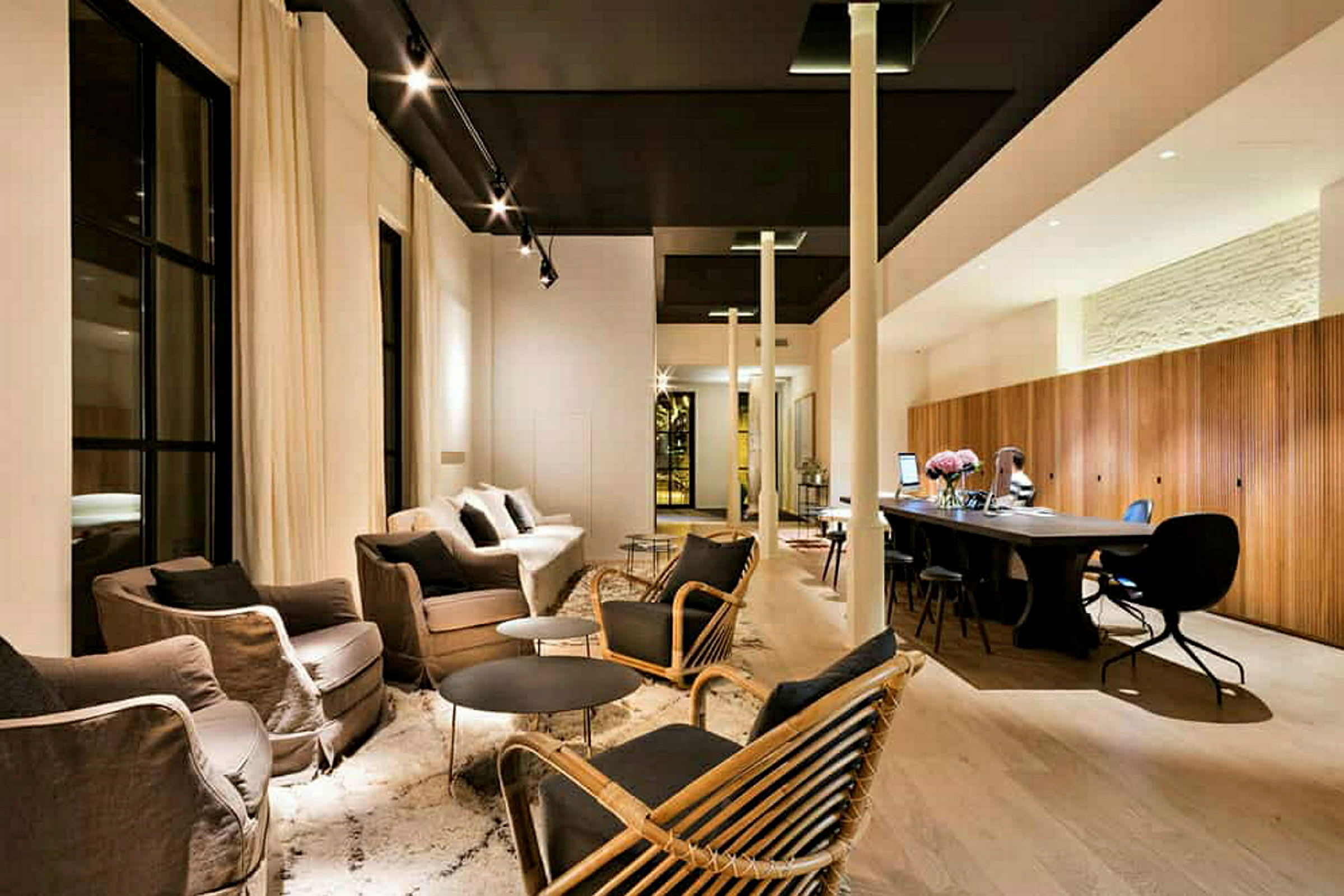 En moderne indrettet lounge med sofaer, lænestole, borde og arbejdsområde. (AI-genereret tekst)