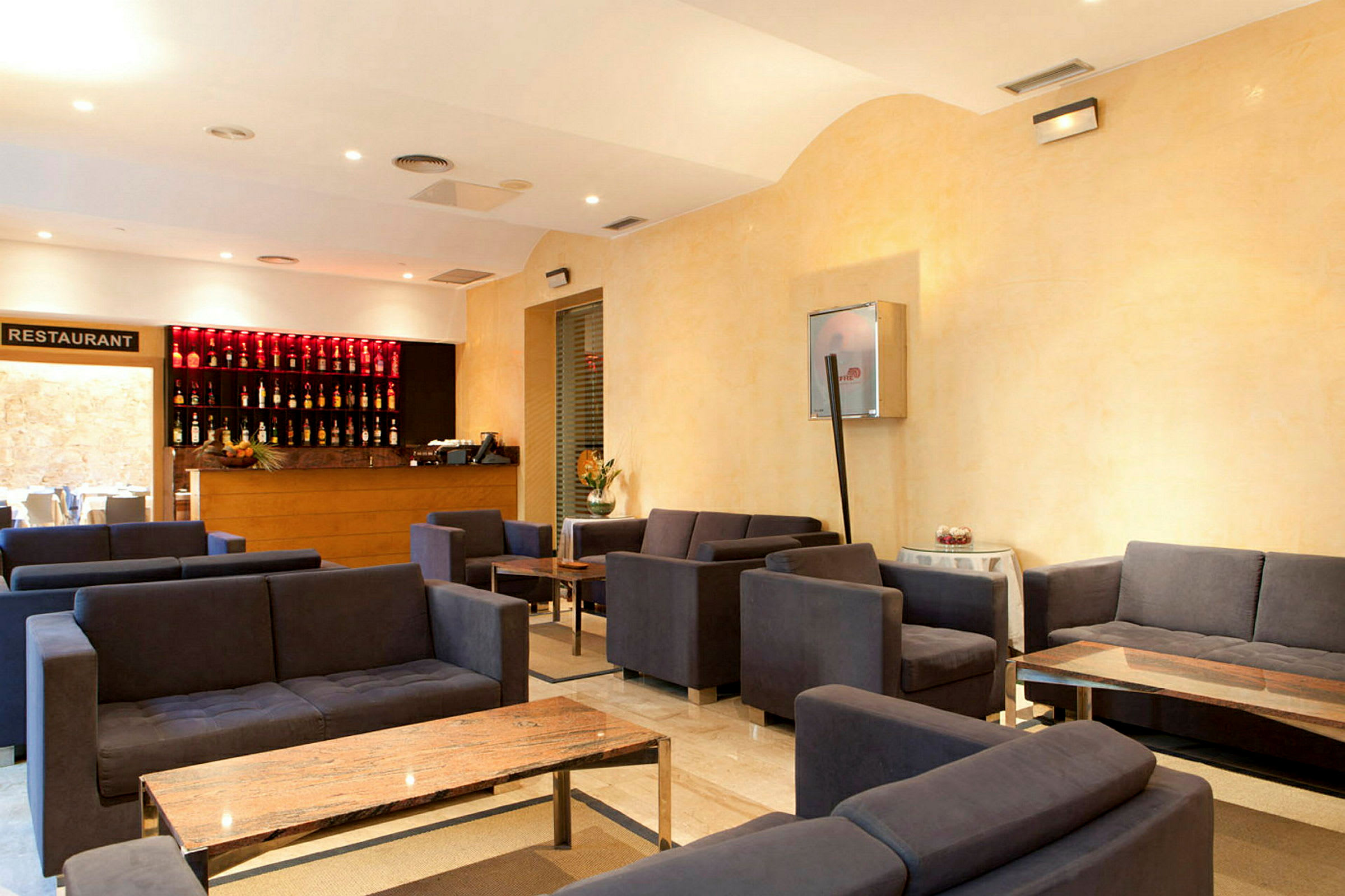 En hotellobby med flere siddegrupper og et receptionsområde. (AI-genereret tekst)