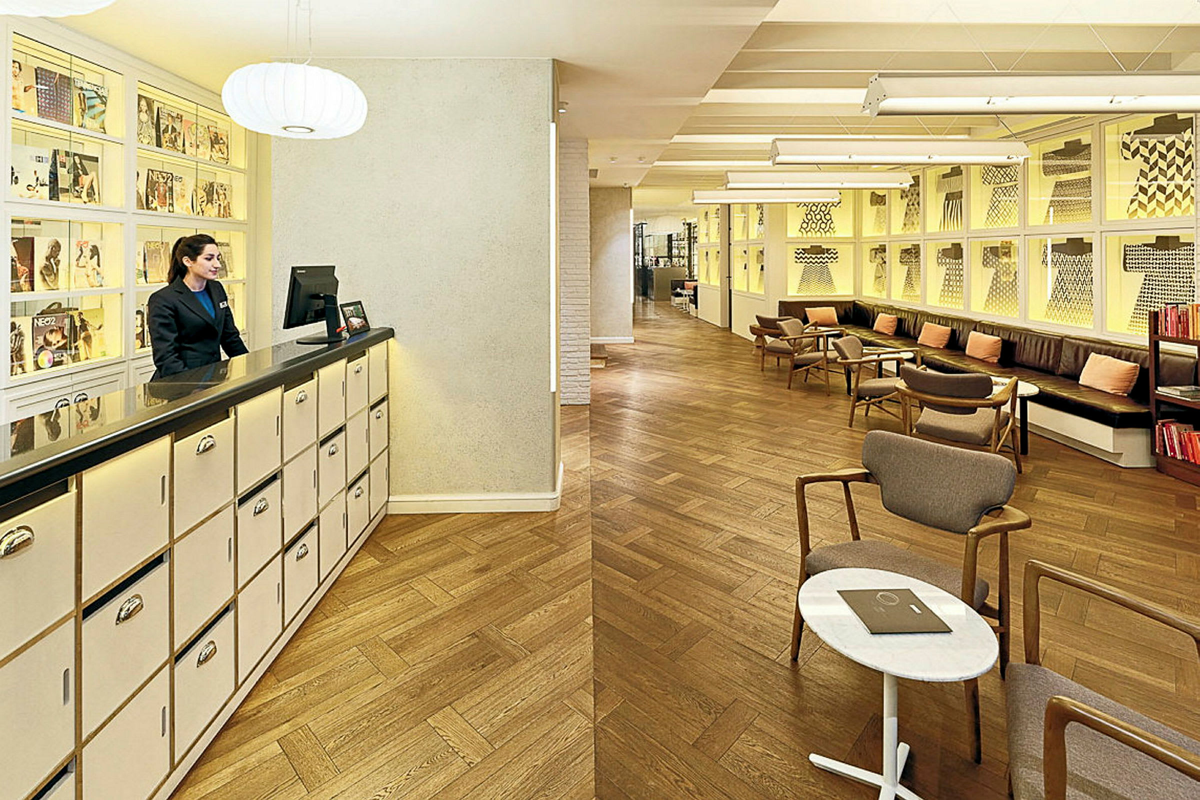 Receptionen på et elegant hotel med moderne indretning, trægulve og kunst på væggene. (AI-genereret tekst)