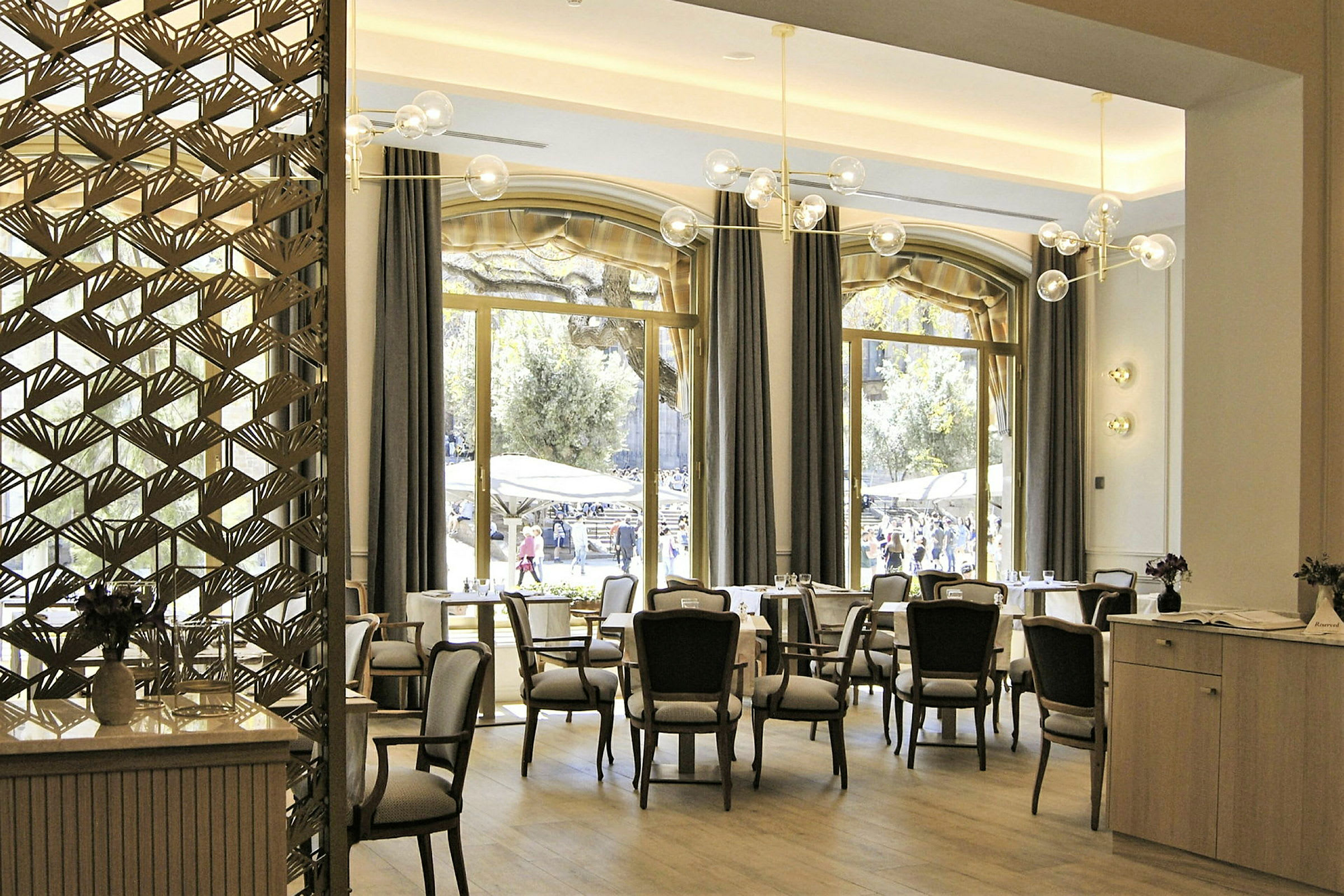 Interiør af en restaurant med store vinduer og elegante møbler. (AI-genereret tekst)