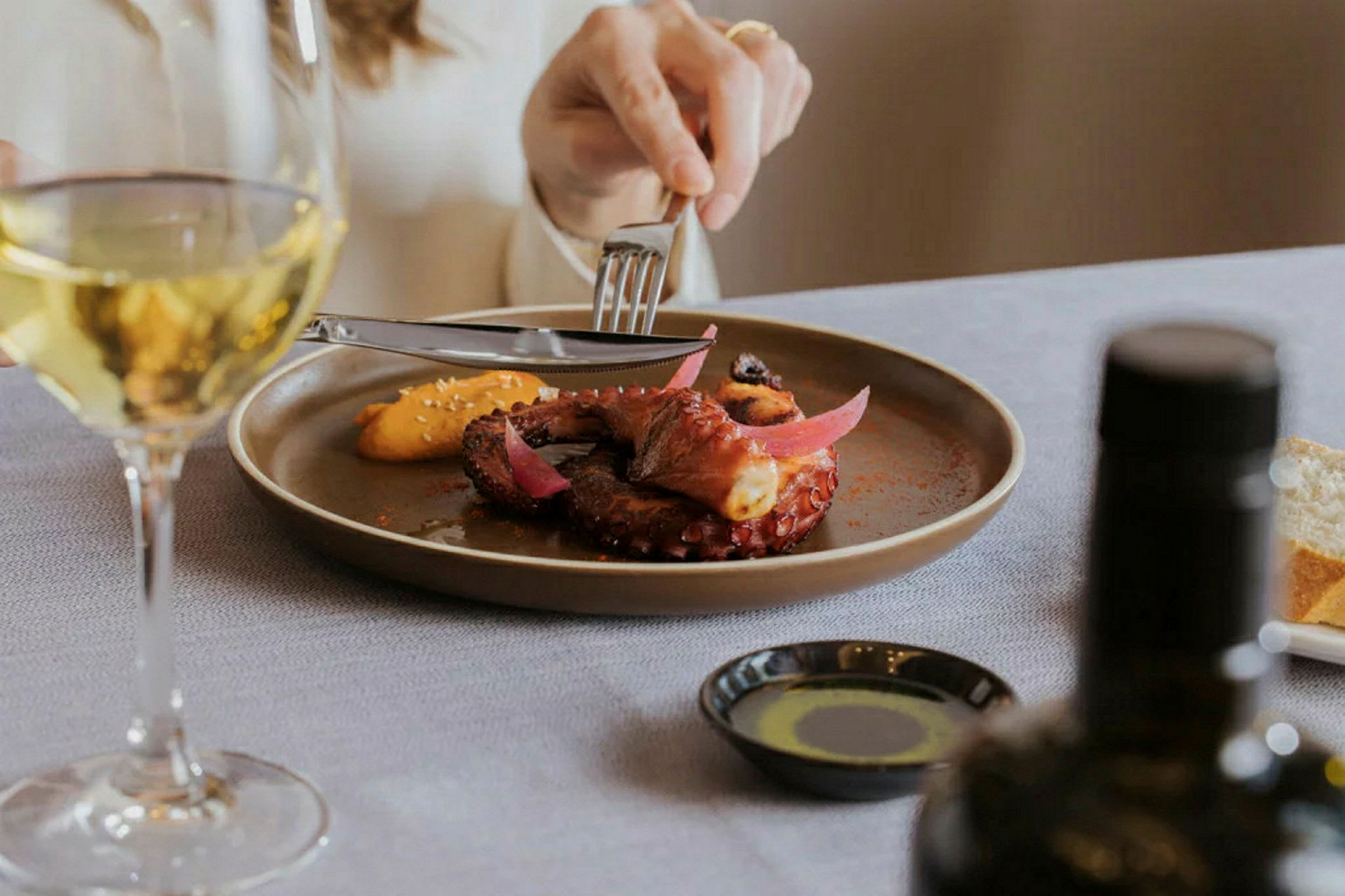Et elegant serveret måltid med tilhørende glas hvidvin. (AI-genereret tekst)