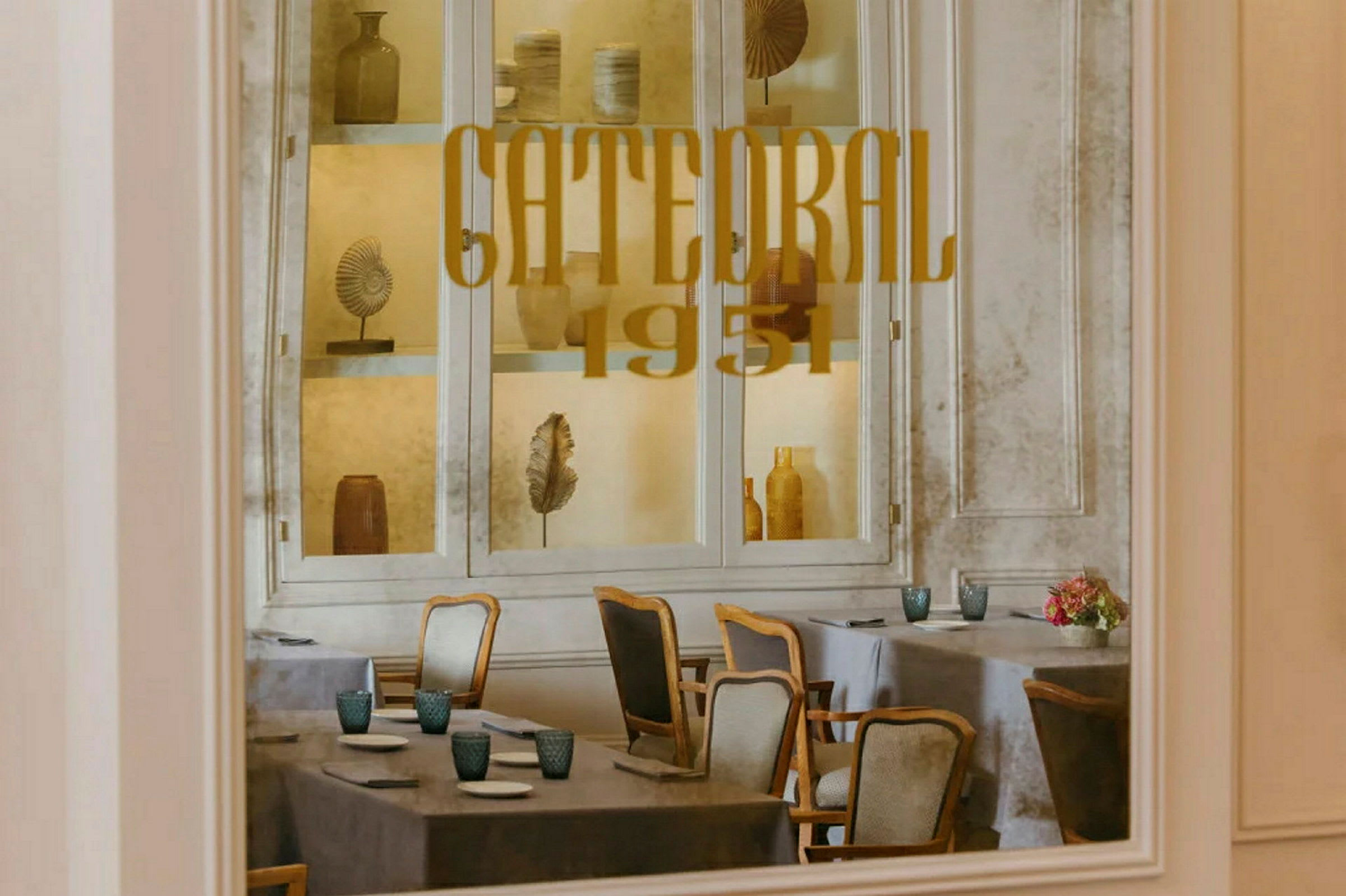 Interiøret af en restaurant med borddækning og dekorationer bag glas. (AI-genereret tekst)