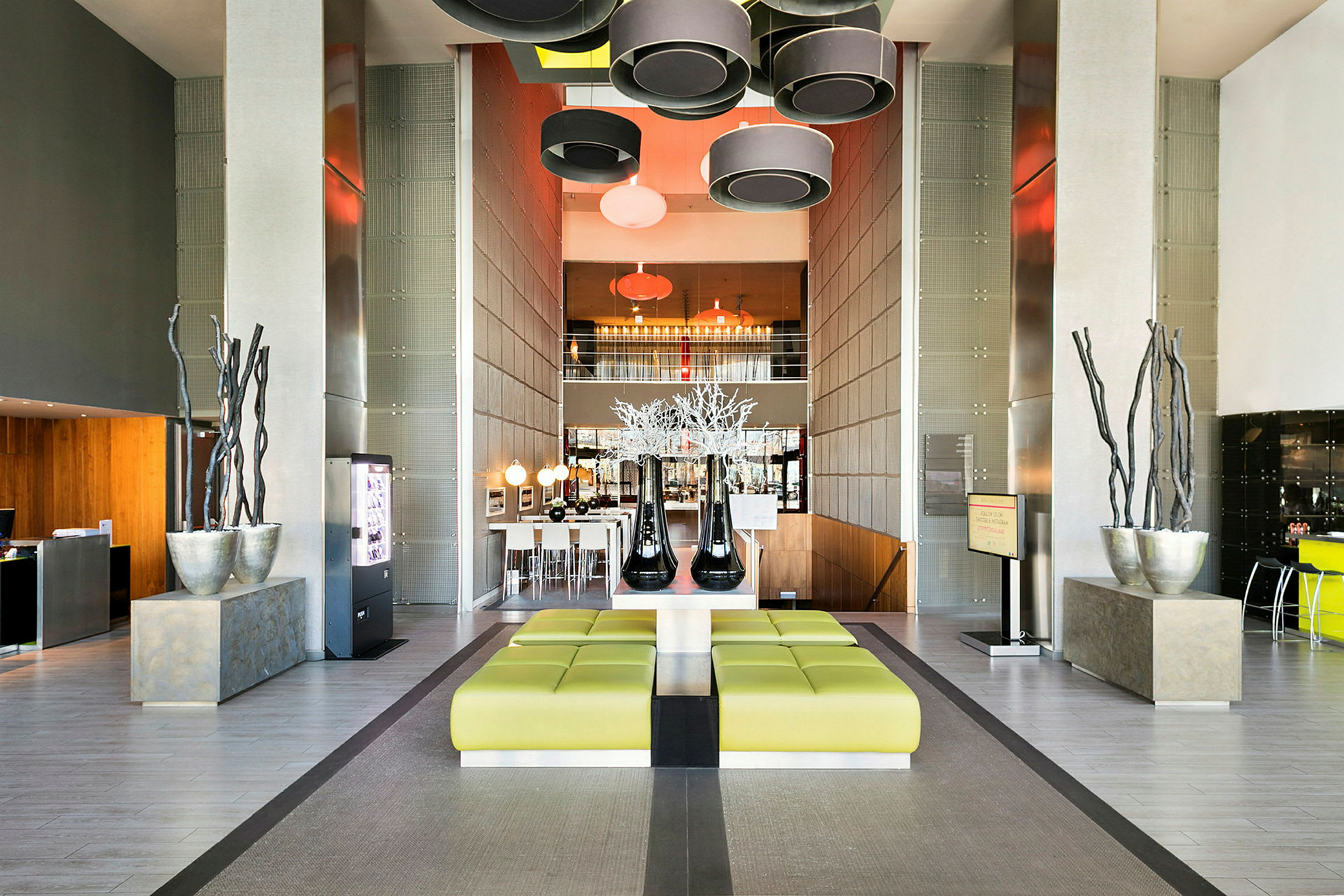 Moderne hotelreception med grønne siddepladser, dekorative elementer og hængende lamper. (AI-genereret tekst)