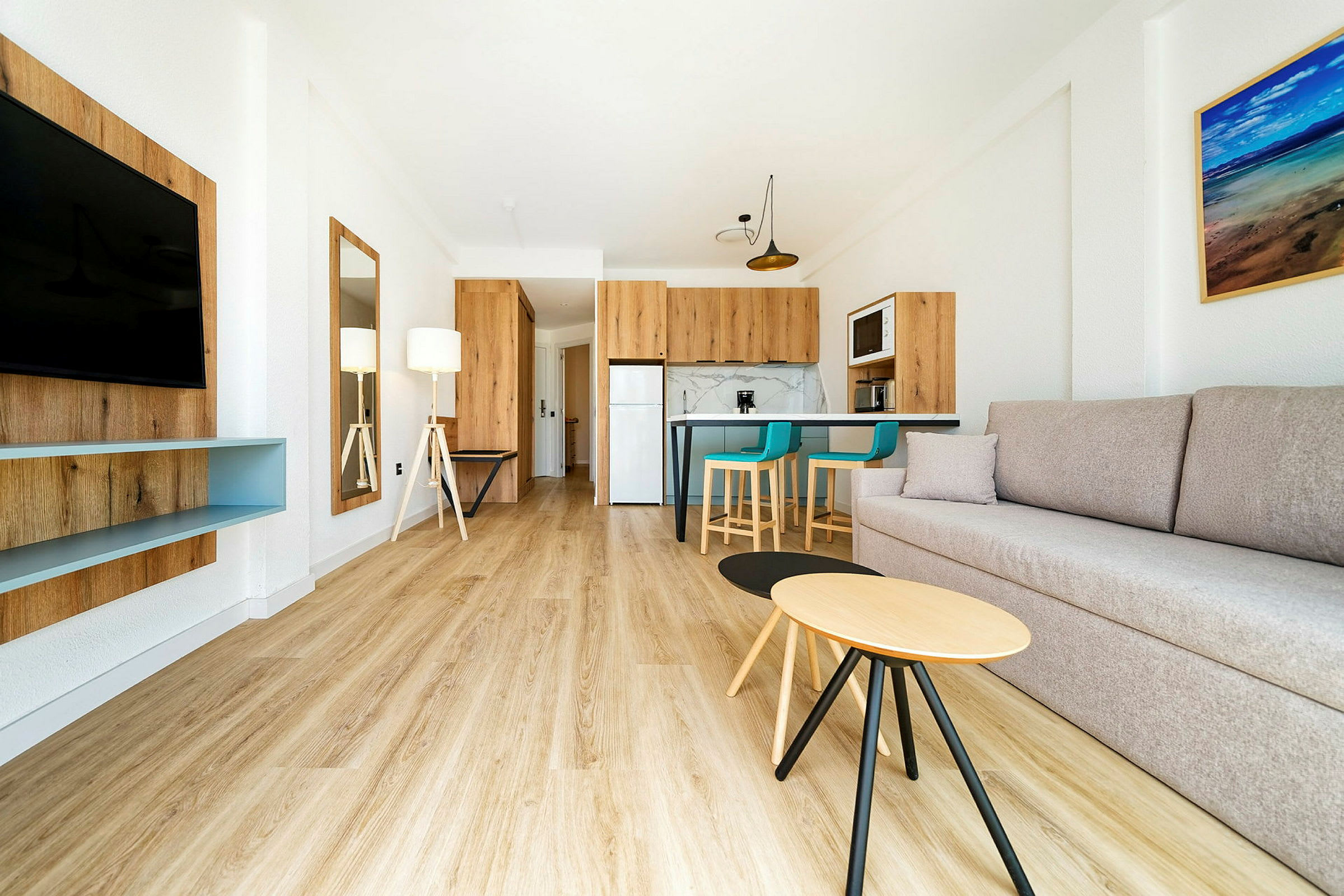 Moderne indrettet stue med sofa, tv, køkken og spiseområde. (AI-genereret tekst)