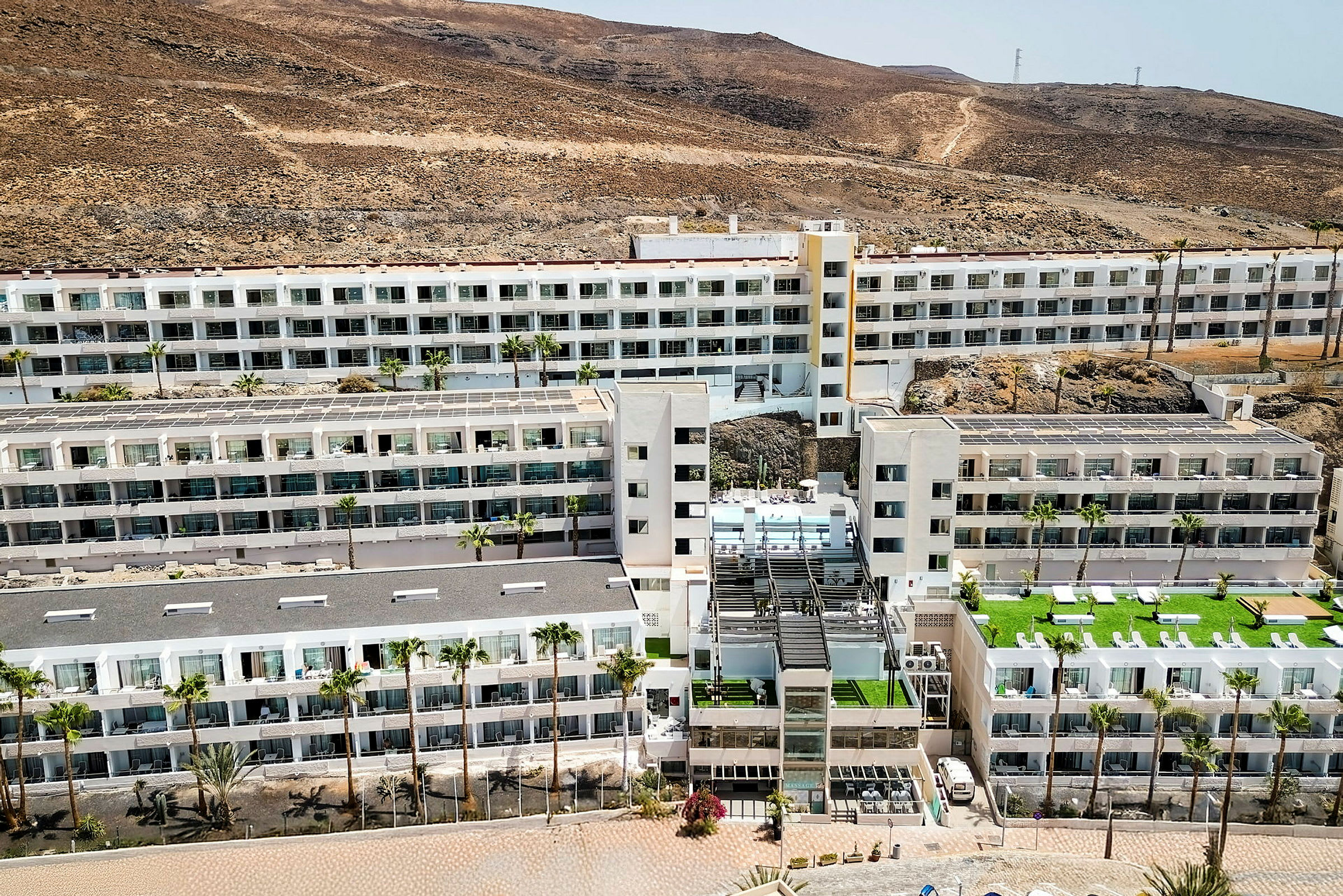 Et stort hotelkompleks omgivet af et tørt, bjergrigt landskab. (AI-genereret tekst)