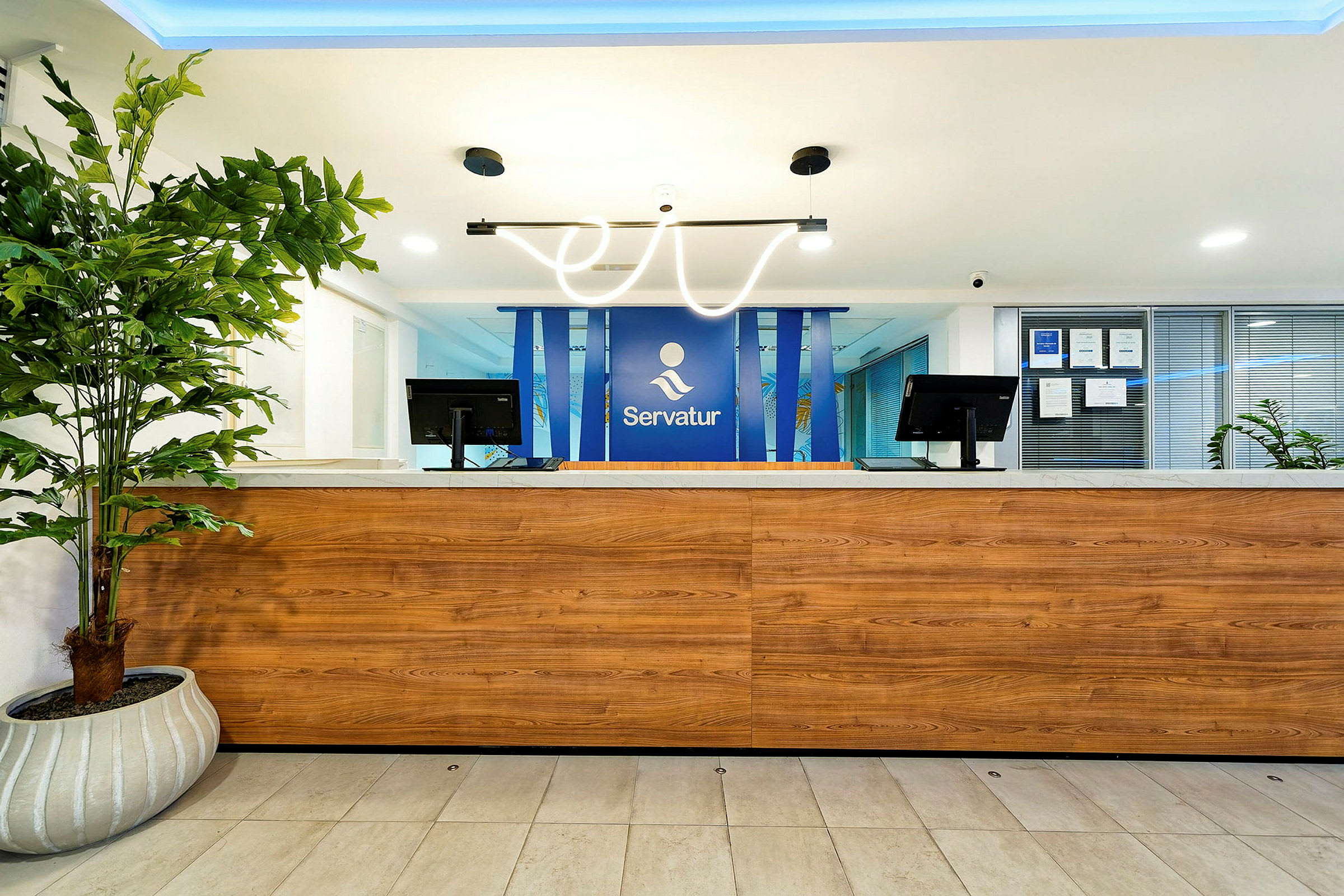 En reception med en træpanel og en blå logobaggrund. (AI-genereret tekst)