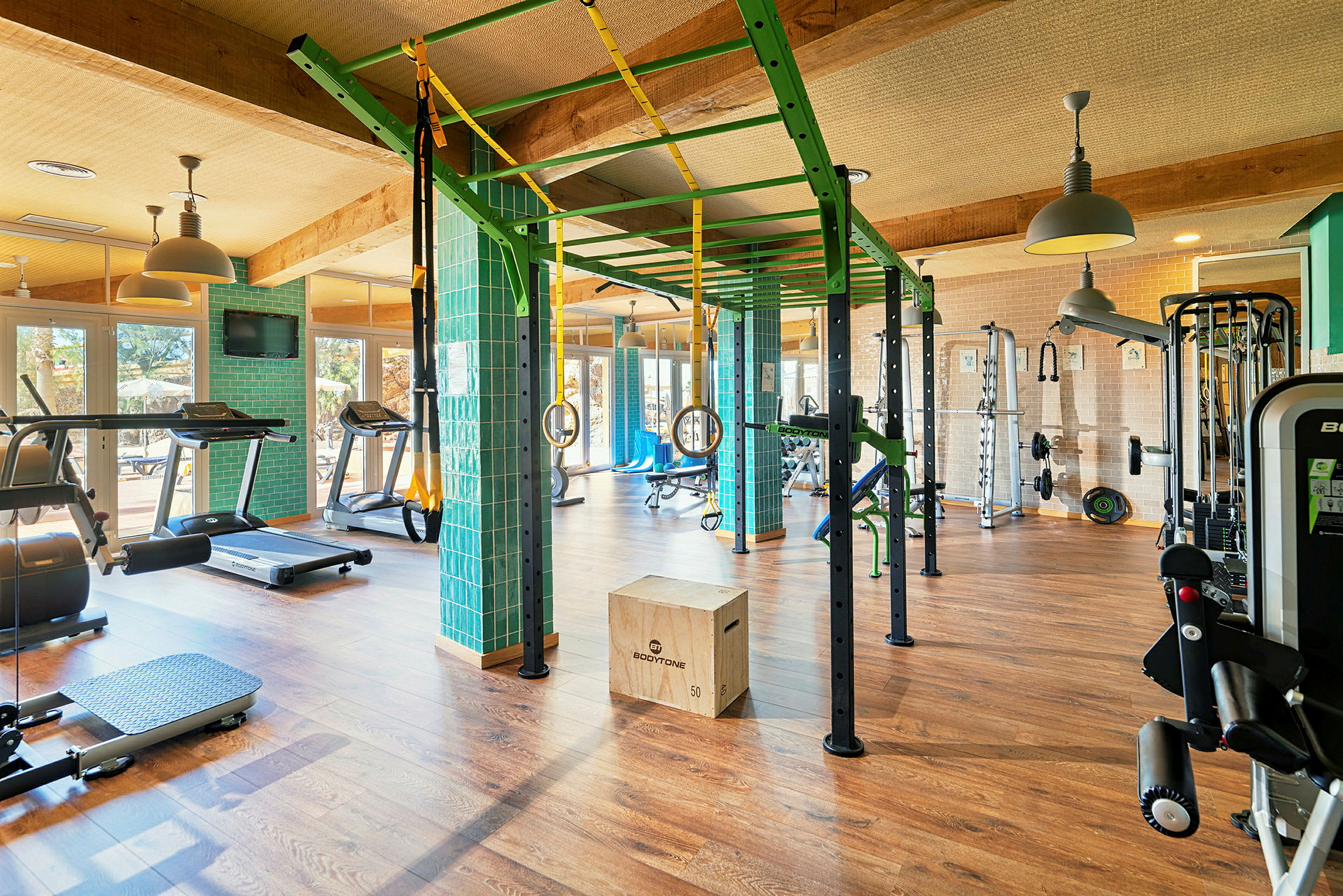 Et fitnesscenter med forskellige træningsudstyr, såsom løbebånd, hoppestænger, vægte og træningsbænke. (AI-genereret tekst)