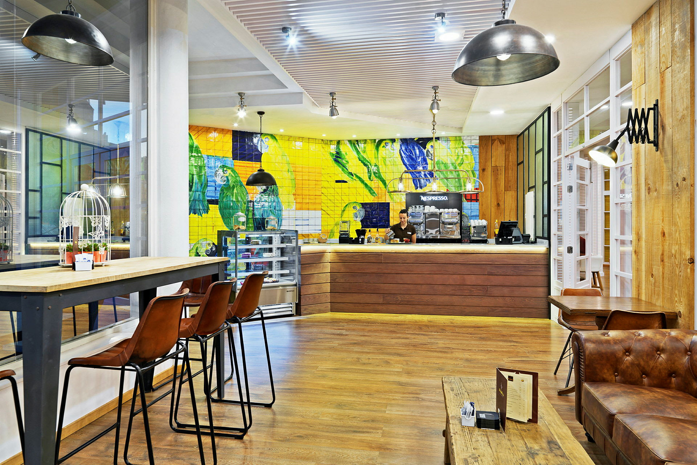Interiør af en café med farverigt flisebelagt væg, høje stole og trædetaljer. (AI-genereret tekst)