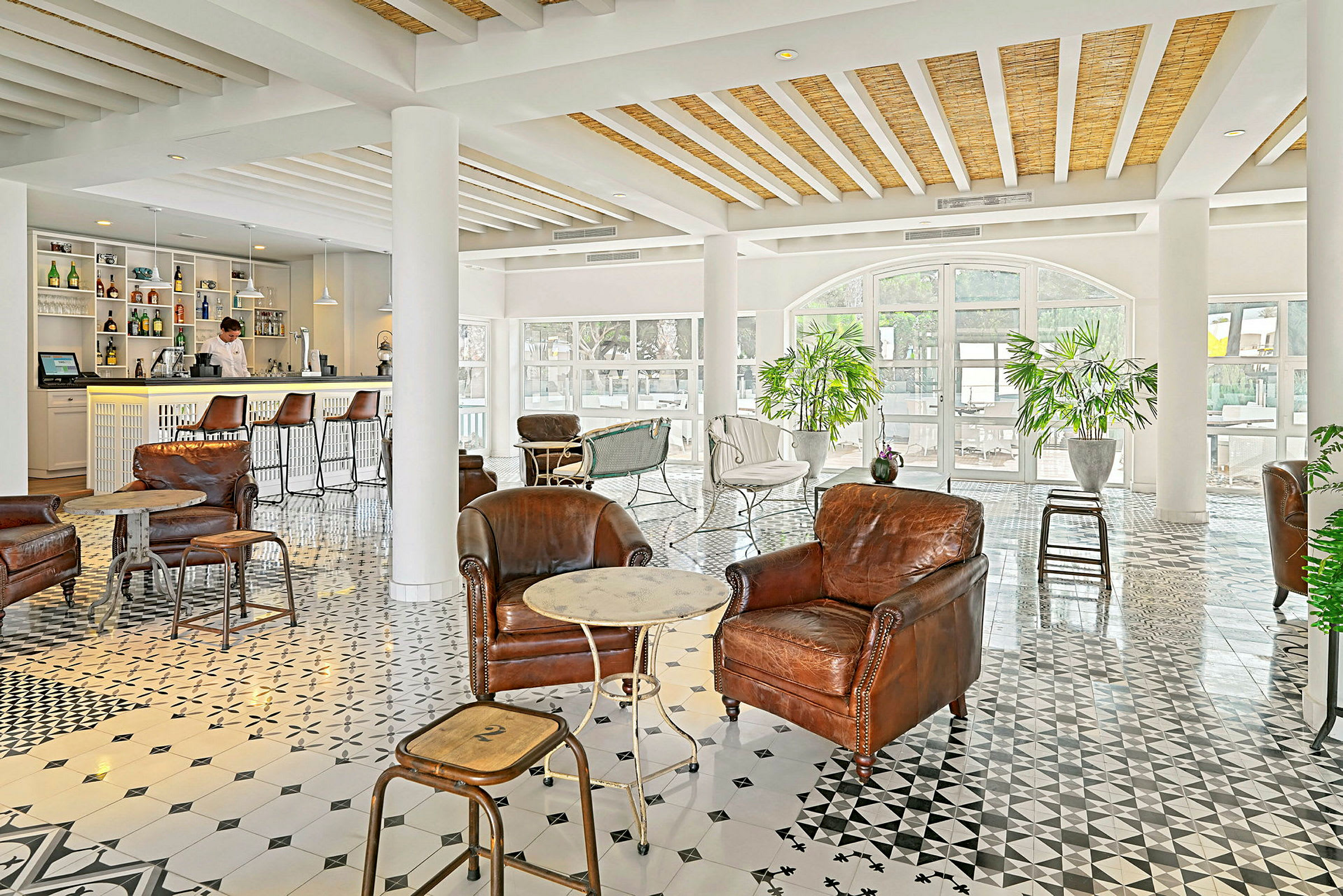 Et elegant indrettet loungeområde med lænestole i læder og en café i baggrunden. (AI-genereret tekst)