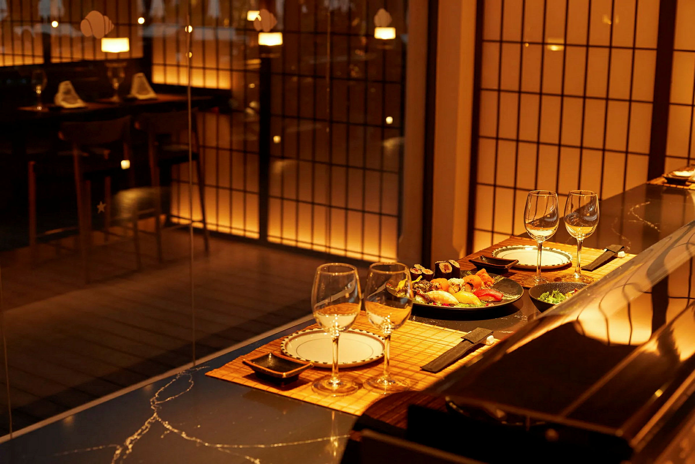 En elegant restaurant med dækket bord og sushi, oplyst af varmt lys. (AI-genereret tekst)