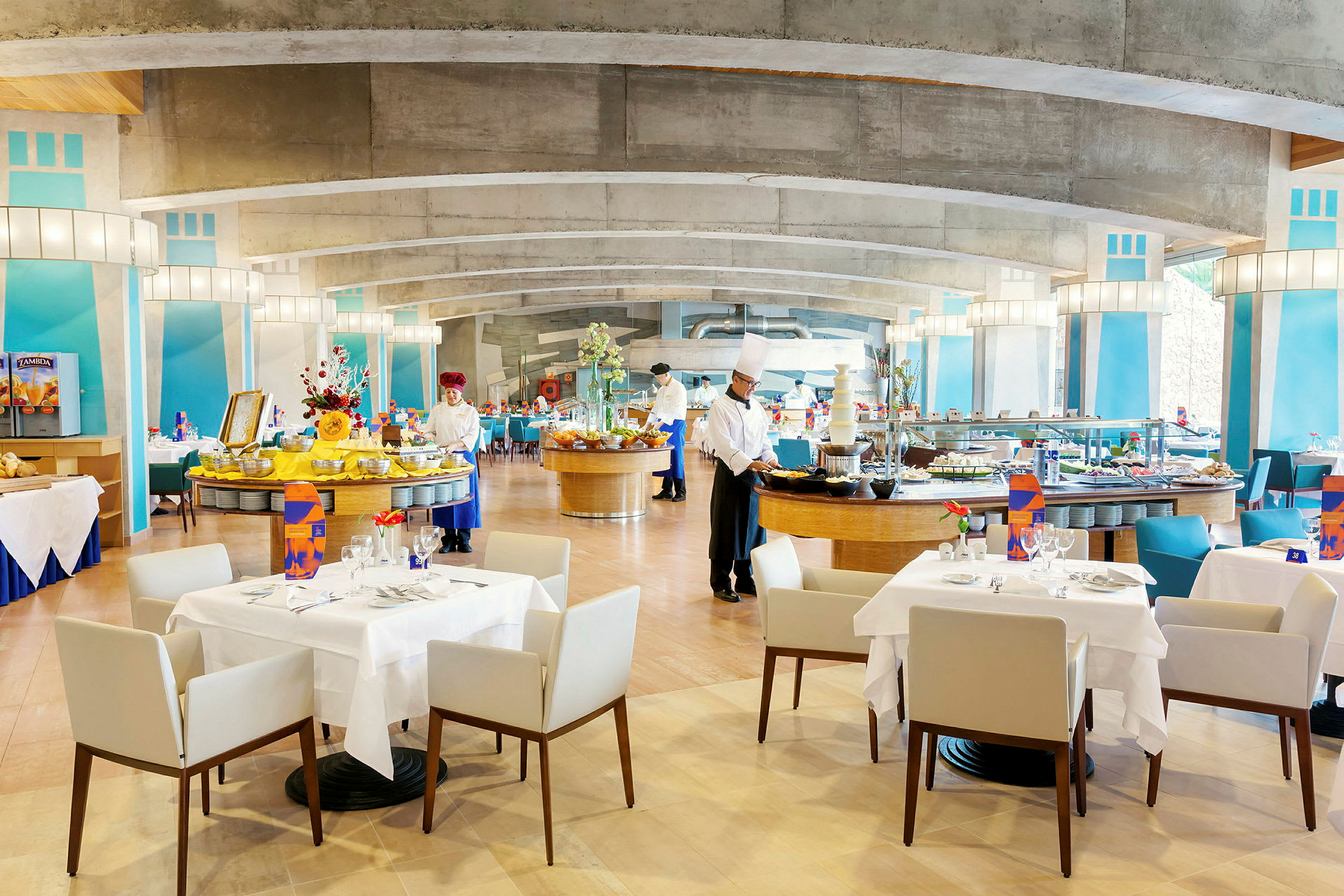 En restaurant med dækkede borde og buffetområde, pyntet med farverige detaljer. (AI-genereret tekst)