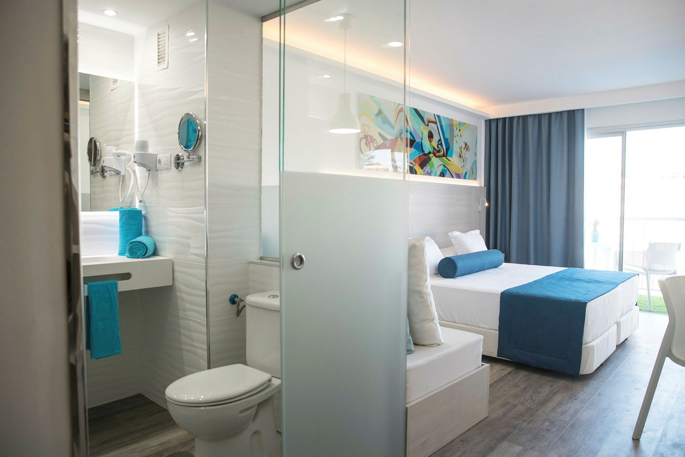 Moderne hotelværelse med seng, badeværelse og balkon. (AI-genereret tekst)