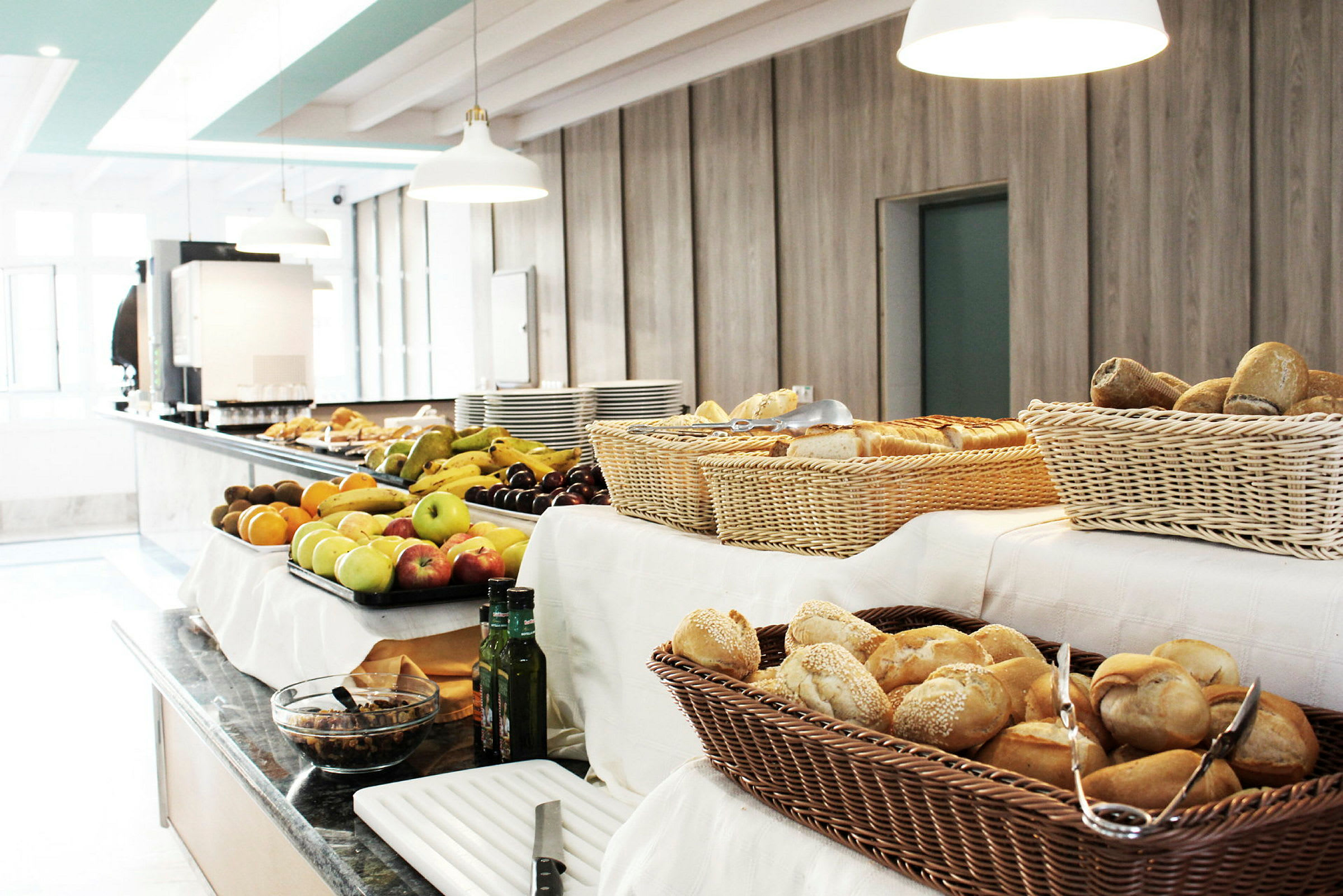 En buffet med frugt, brød og andre tilbehør på et bord. (AI-genereret tekst)