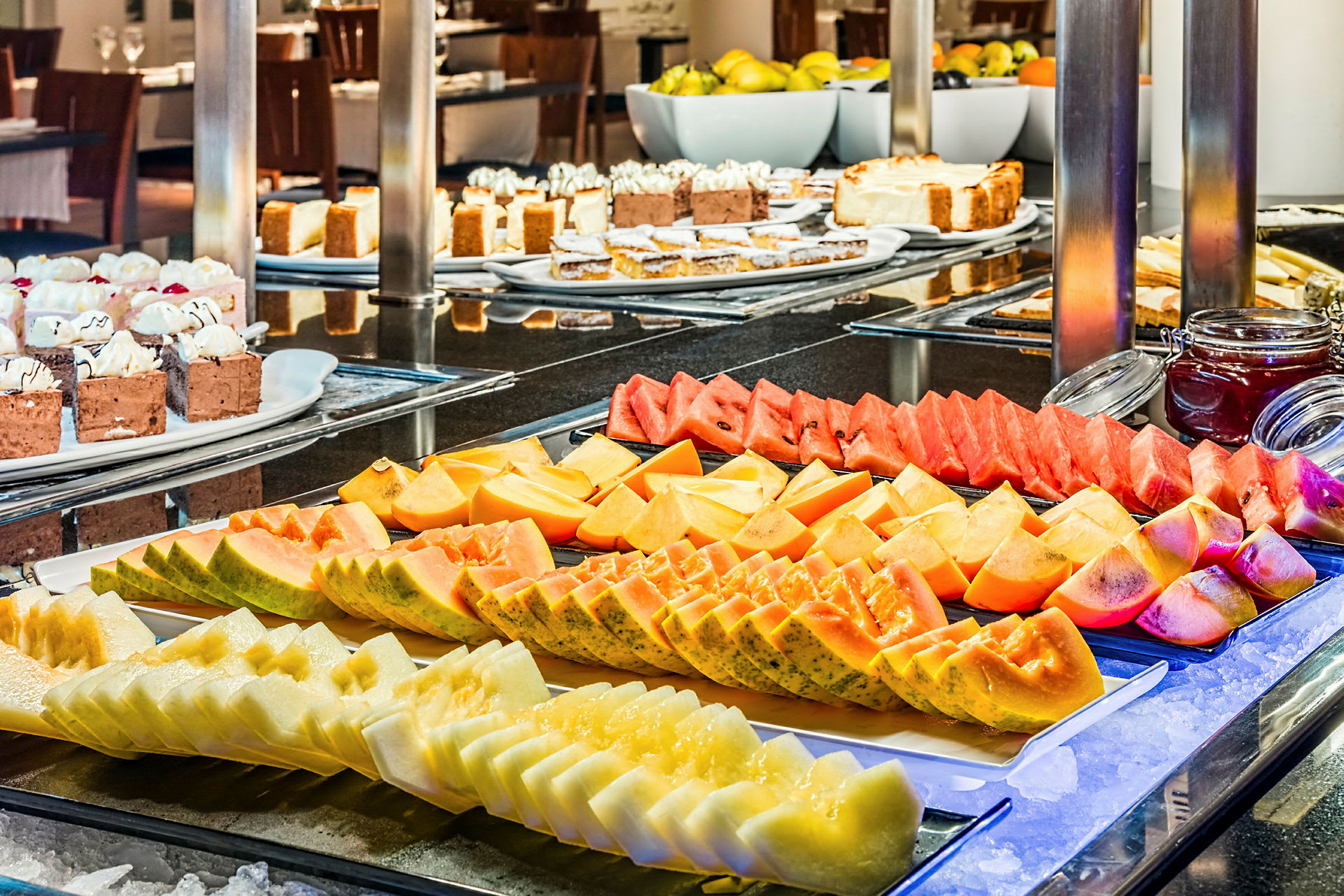 Buffet med frisk frugt og desserter på et serveringsbord. (AI-genereret tekst)