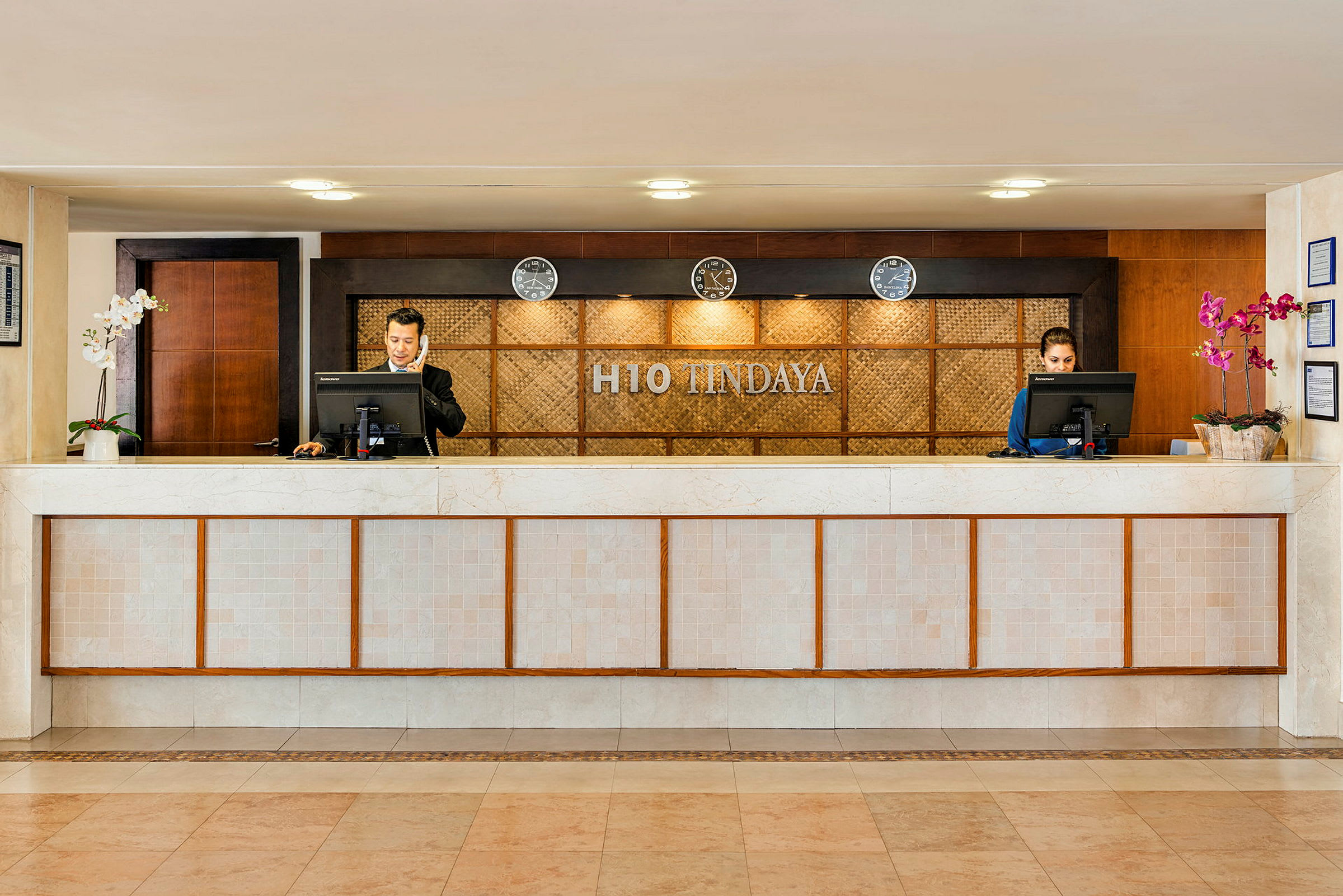 Receptionen på H10 Tindaya med to receptionsskranker og personale. (AI-genereret tekst)