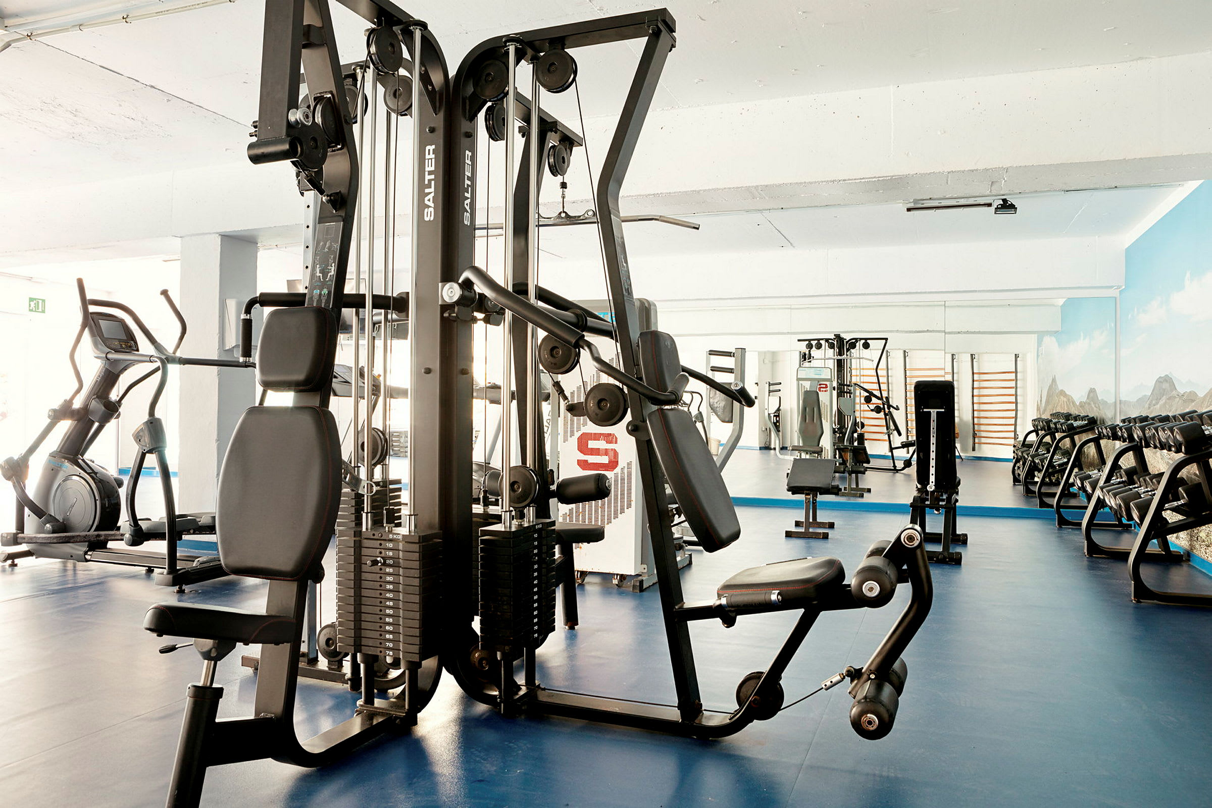 Et fitnesscenter med træningsmaskiner og frie vægte. (AI-genereret tekst)