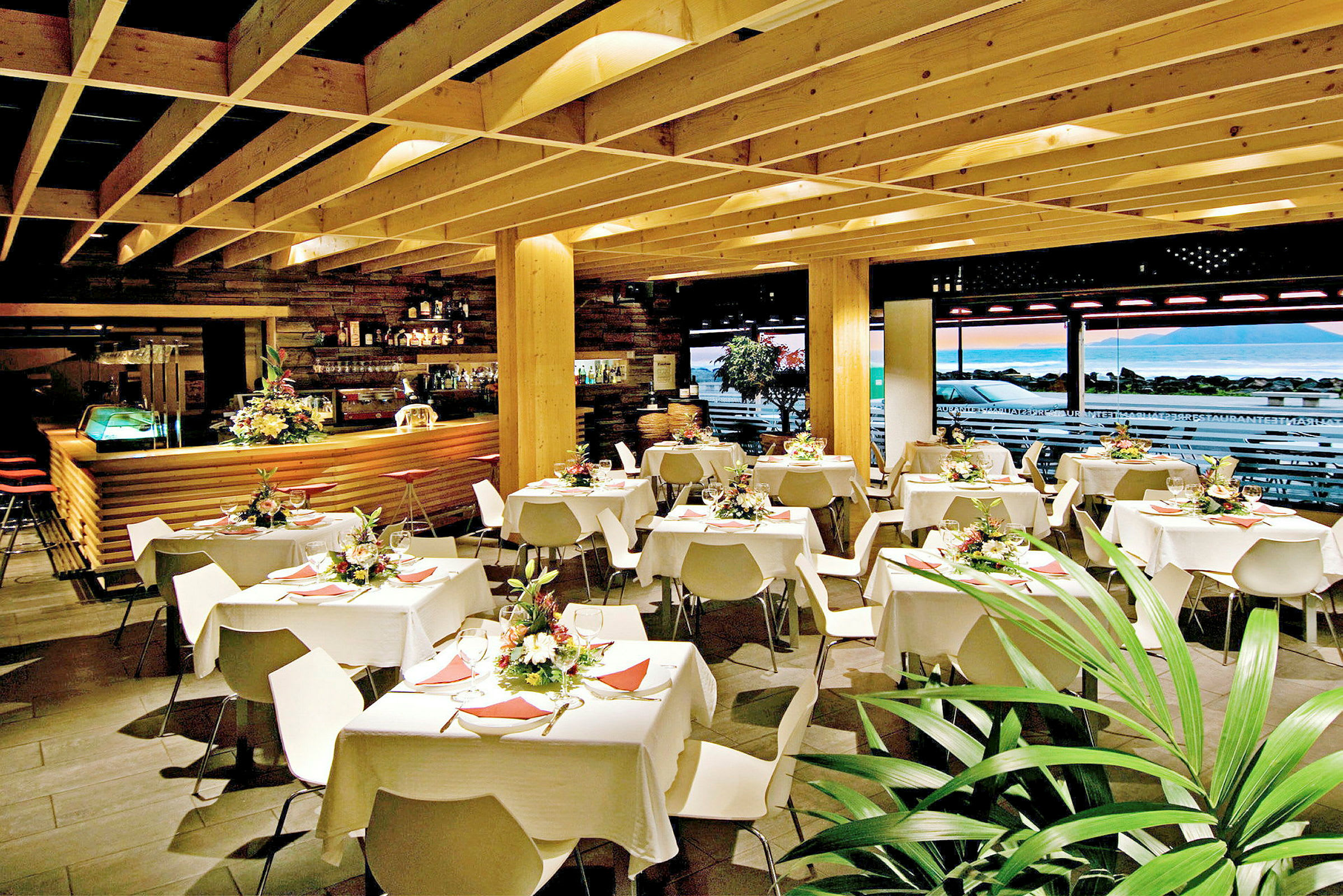 Restaurantinteriør med dækkede borde og dekorative blomster. (AI-genereret tekst)