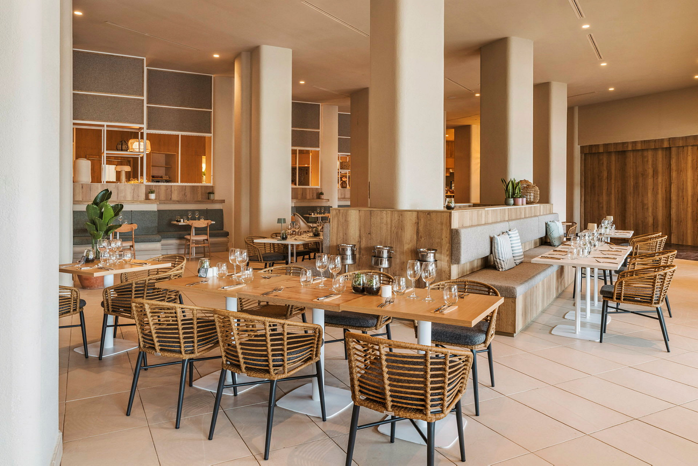 En rummelig og elegant indrettet restaurant med træborde og flettede stole. (AI-genereret tekst)