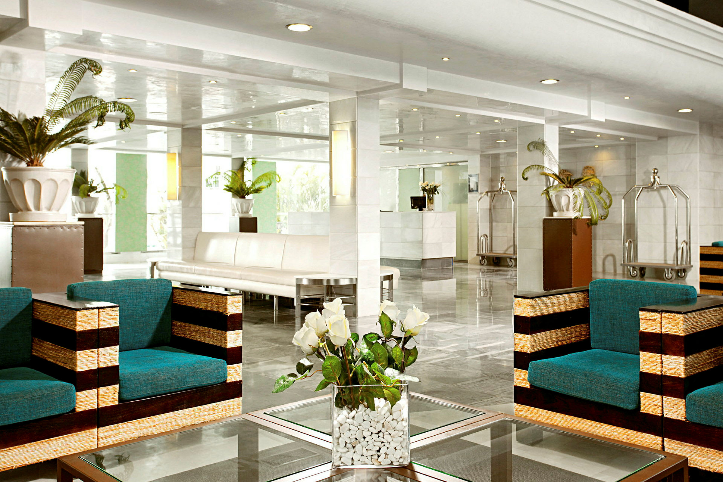 Interiørbillede af en hotellobby med moderne møbler, planter og reception i baggrunden. (AI-genereret tekst)