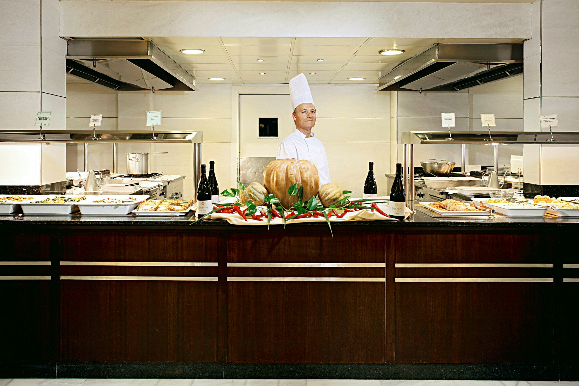 En buffet med forskellige retter egnet til frokost eller middag, med en dekoration af græskar og chili i midten. (AI-genereret tekst)