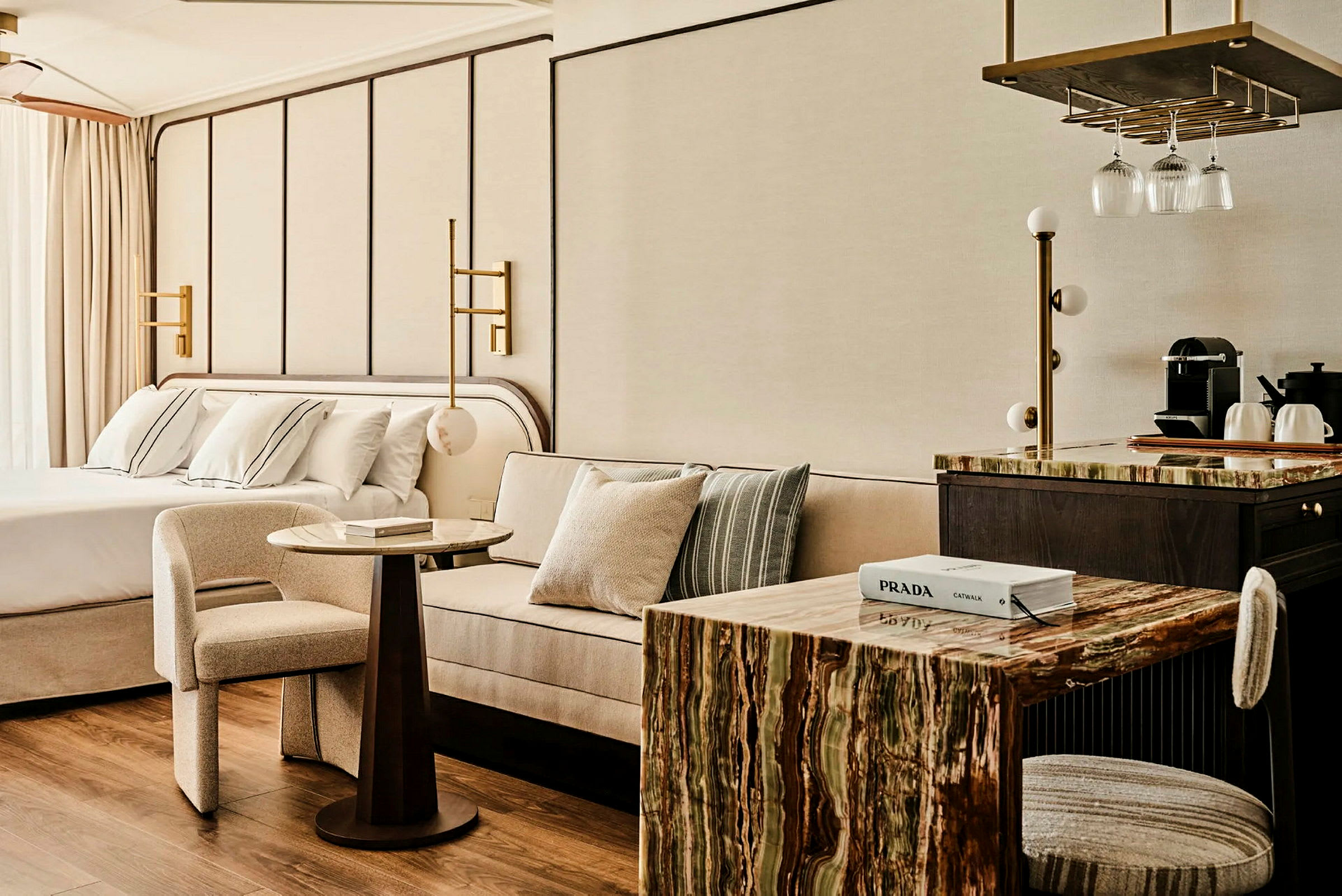 Et moderne hotelværelse med seng, sofa, bord og et te-køkken. (AI-genereret tekst)