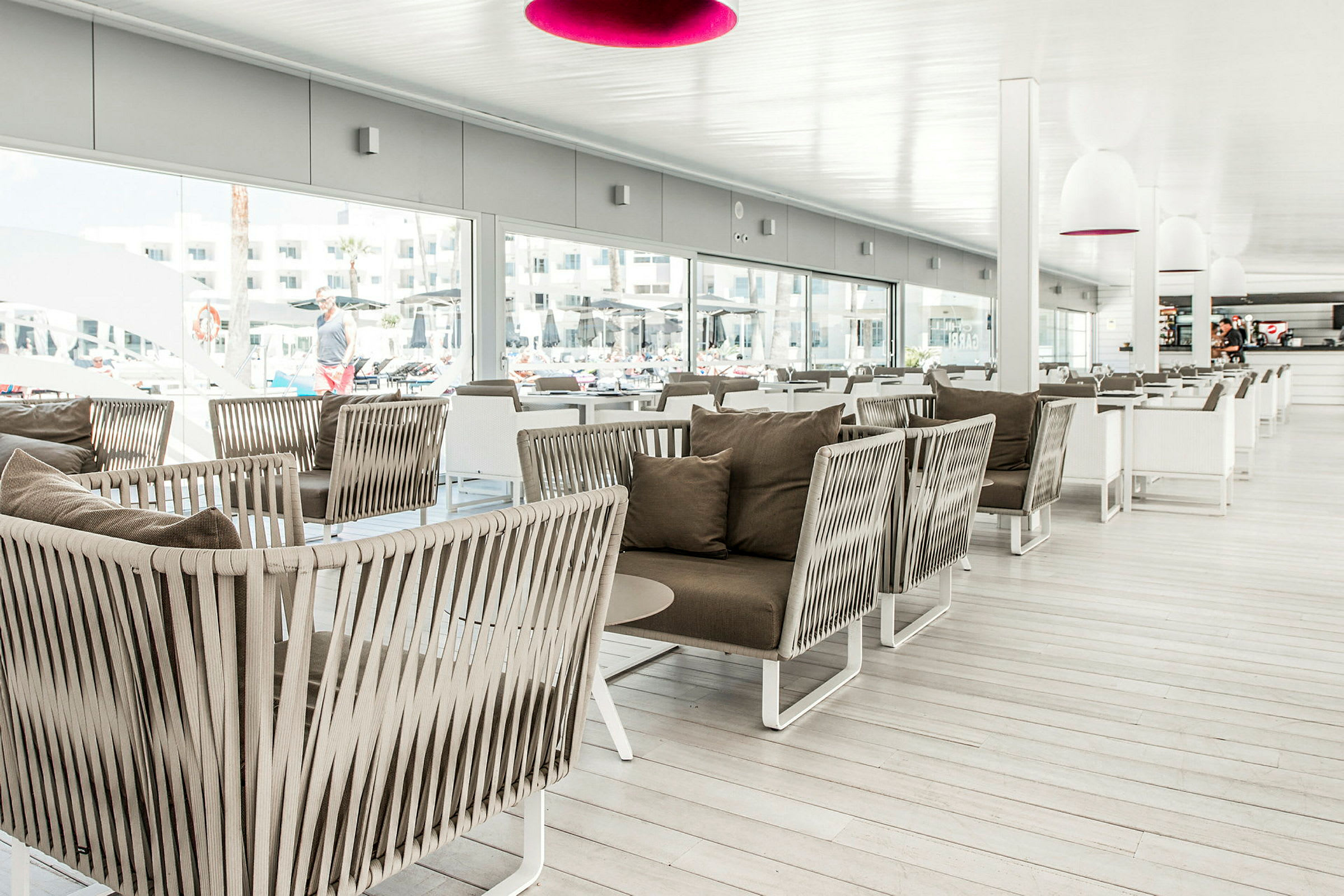 En moderne indendørs lounge med komfortable rattanstole og borde. (AI-genereret tekst)