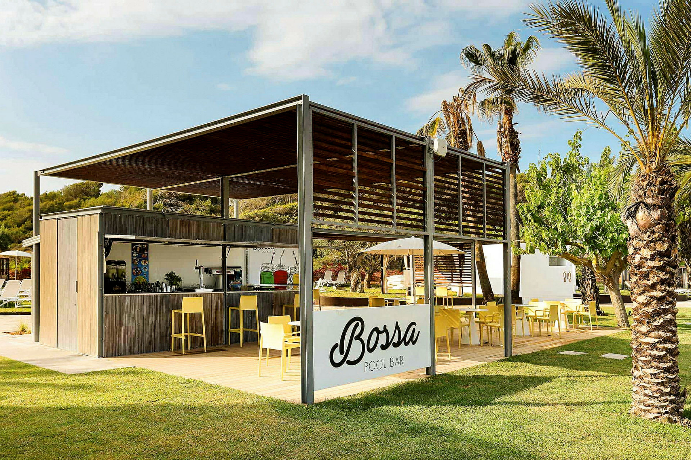 En udendørs poolbar med skiltet 'Bossa Pool Bar', omgivet af frodighed og palmer. Der er siddepladser med gule stole og borde. (AI-genereret tekst)