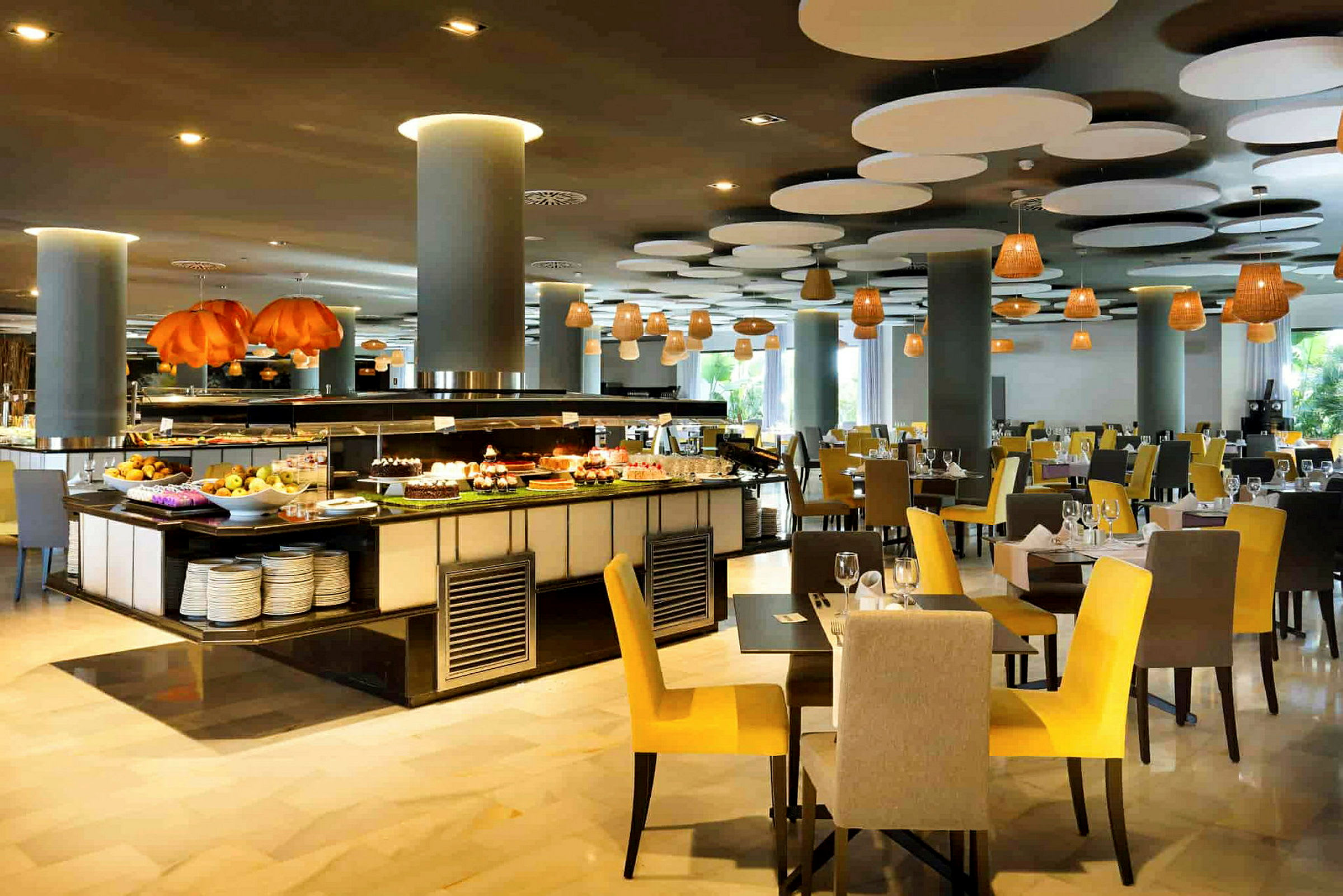 Restaurant med opfyldte borde og buffetområde fyldt med forskellige retter. (AI-genereret tekst)